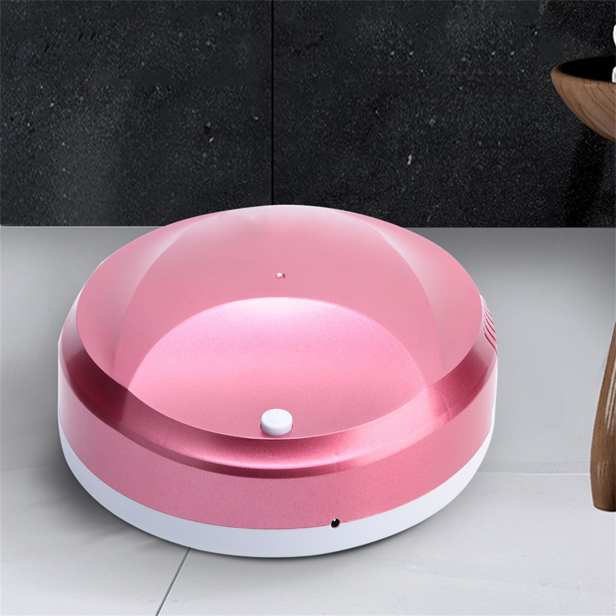 Ein rosa, runder, automatischer Reinigungsroboter auf einer weißen Oberfläche.