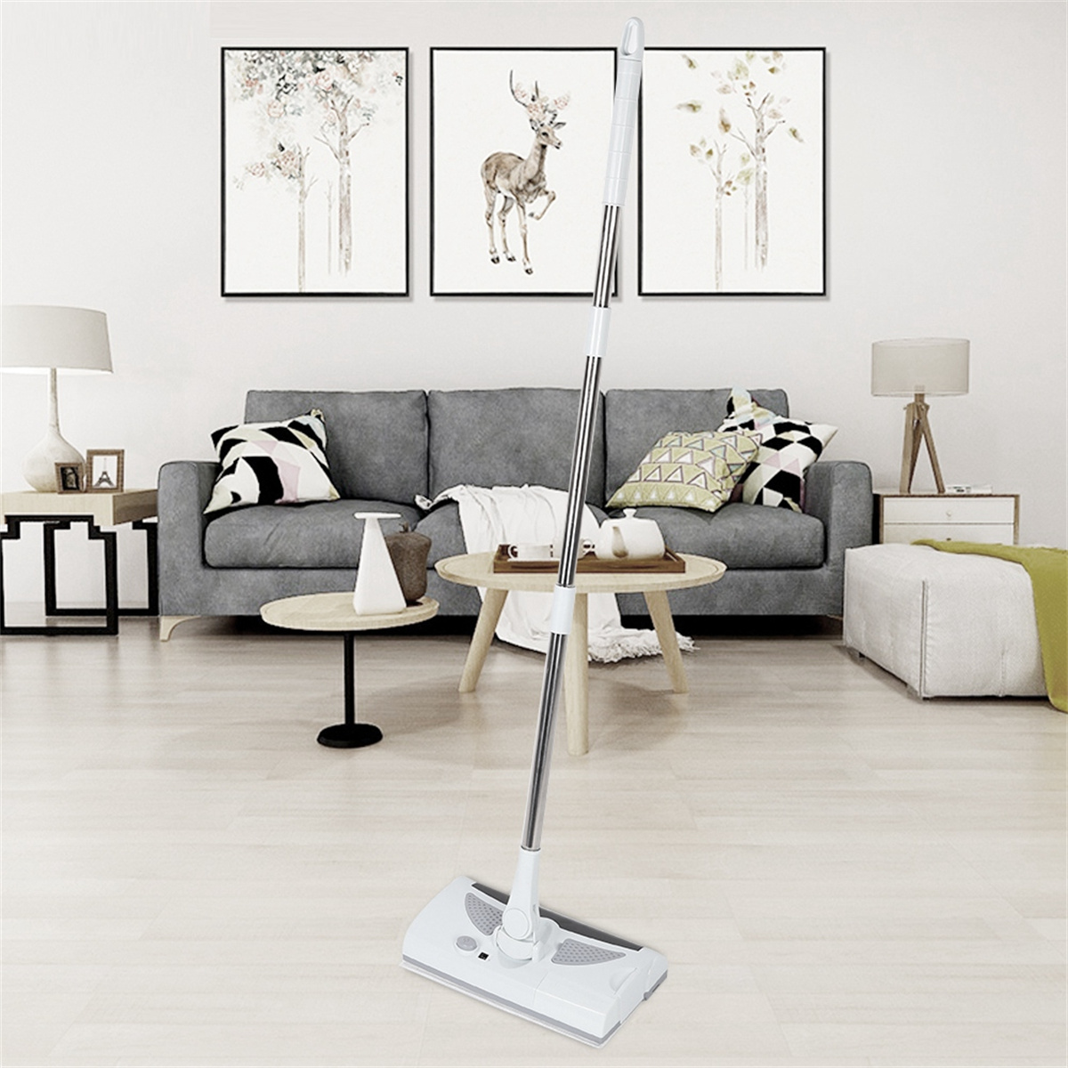 Ein weißer Wischmopp steht aufrecht in einem Wohnzimmer mit grauem Sofa, Kunst und Couchtisch.