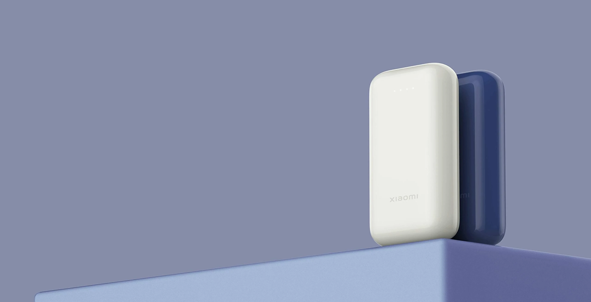 Twee powerbanks, wit en blauw, op een blauw voetstuk, met het Xiaomi-logo.