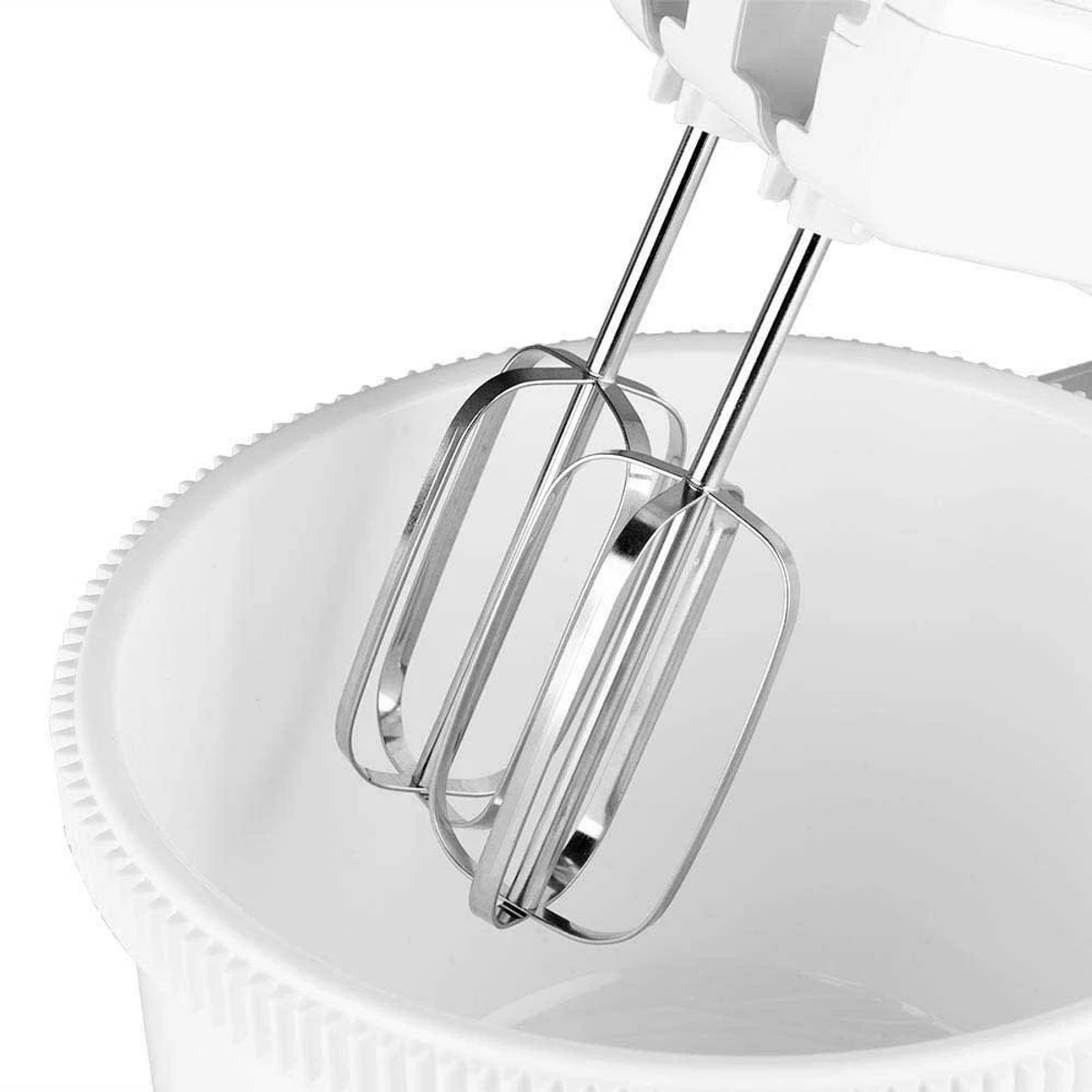 Un frullatore a mano elettrico bianco con due fruste in acciaio inossidabile, posto in una ciotola bianca.