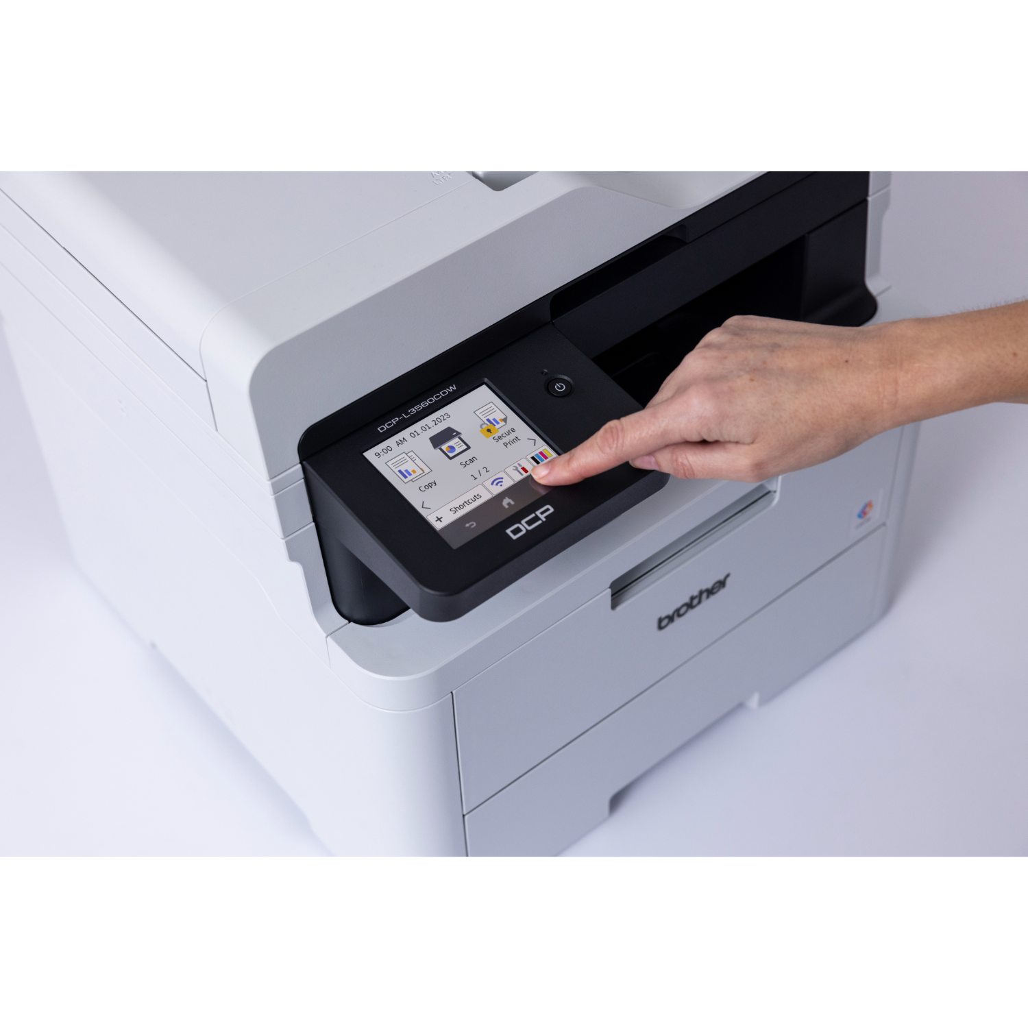 Ręka naciska ekran dotykowy na białej i szarej drukarce Brother.