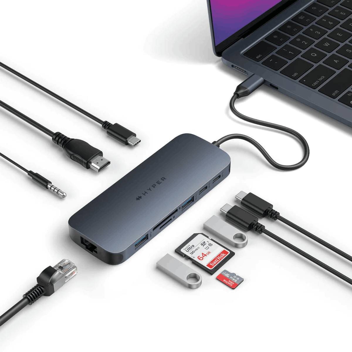 Un hub USB-C con vari dispositivi collegati: cavi, unità USB, schede SD e un laptop.