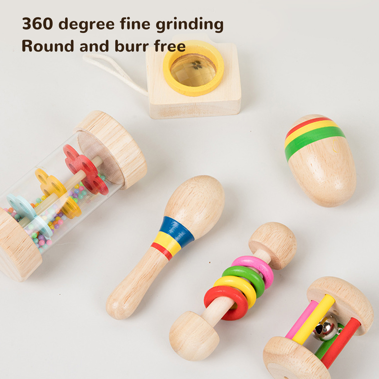 Verschiedene Holzspielzeuge für Babys: eine Maraca, eine Rassel und ein Holzspielzeug mit Spiegel, alle auf weißem Untergrund.