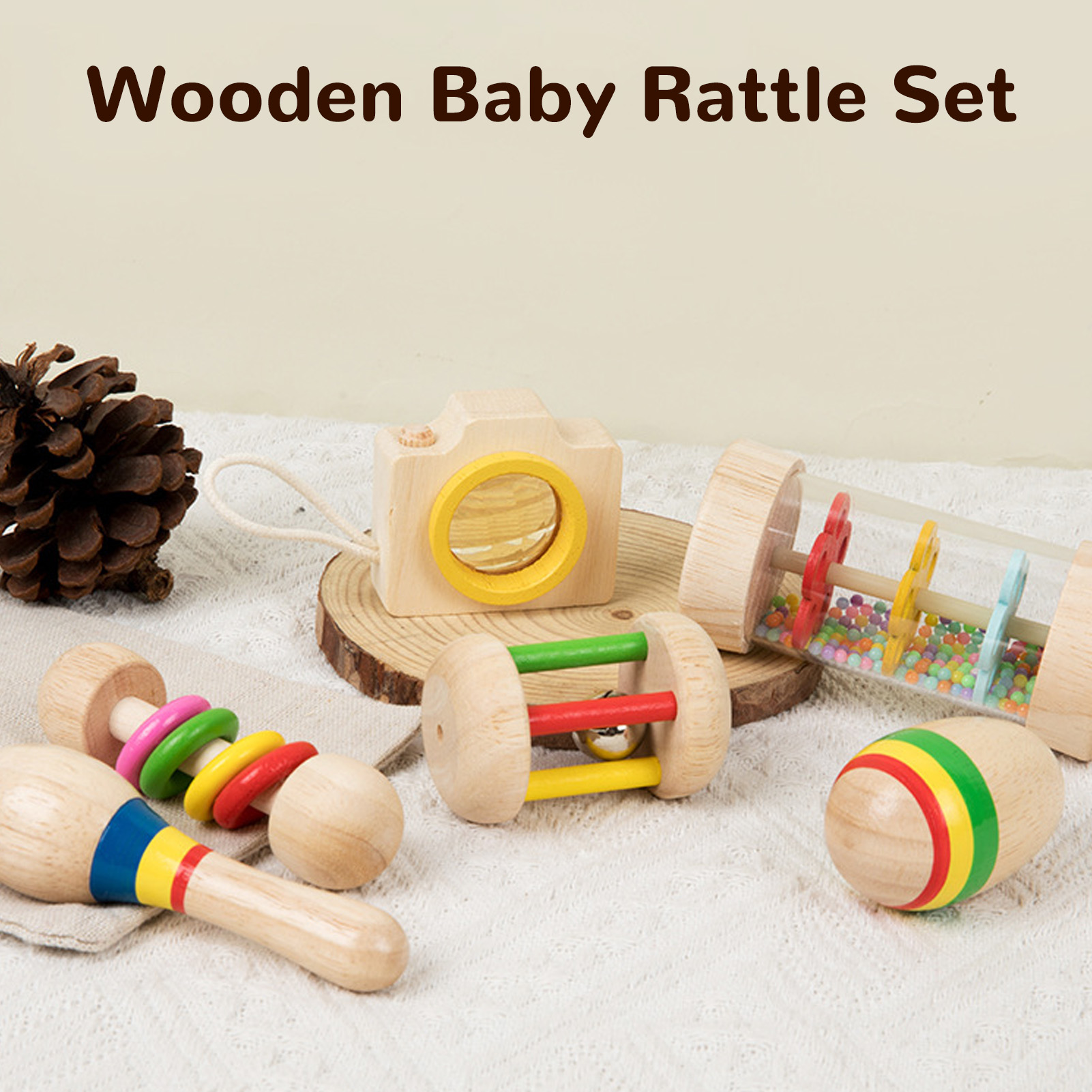 Hölzernes Babyrassel-Set. Enthält eine Kamera, Maracas, eine Rolle und andere Spielzeuge auf weißem Untergrund.