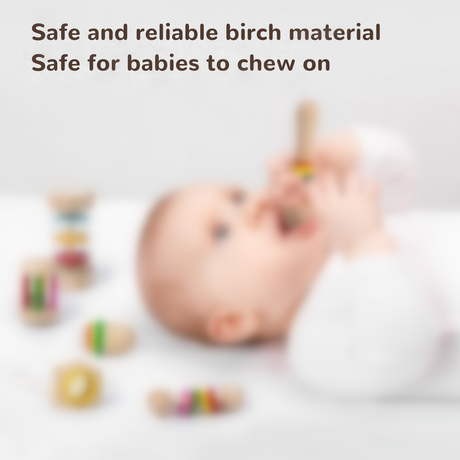 Baby mit Holzspielzeug. Spielzeug ist bunt. Text weist auf sicheres Birkenmaterial für Babys hin.