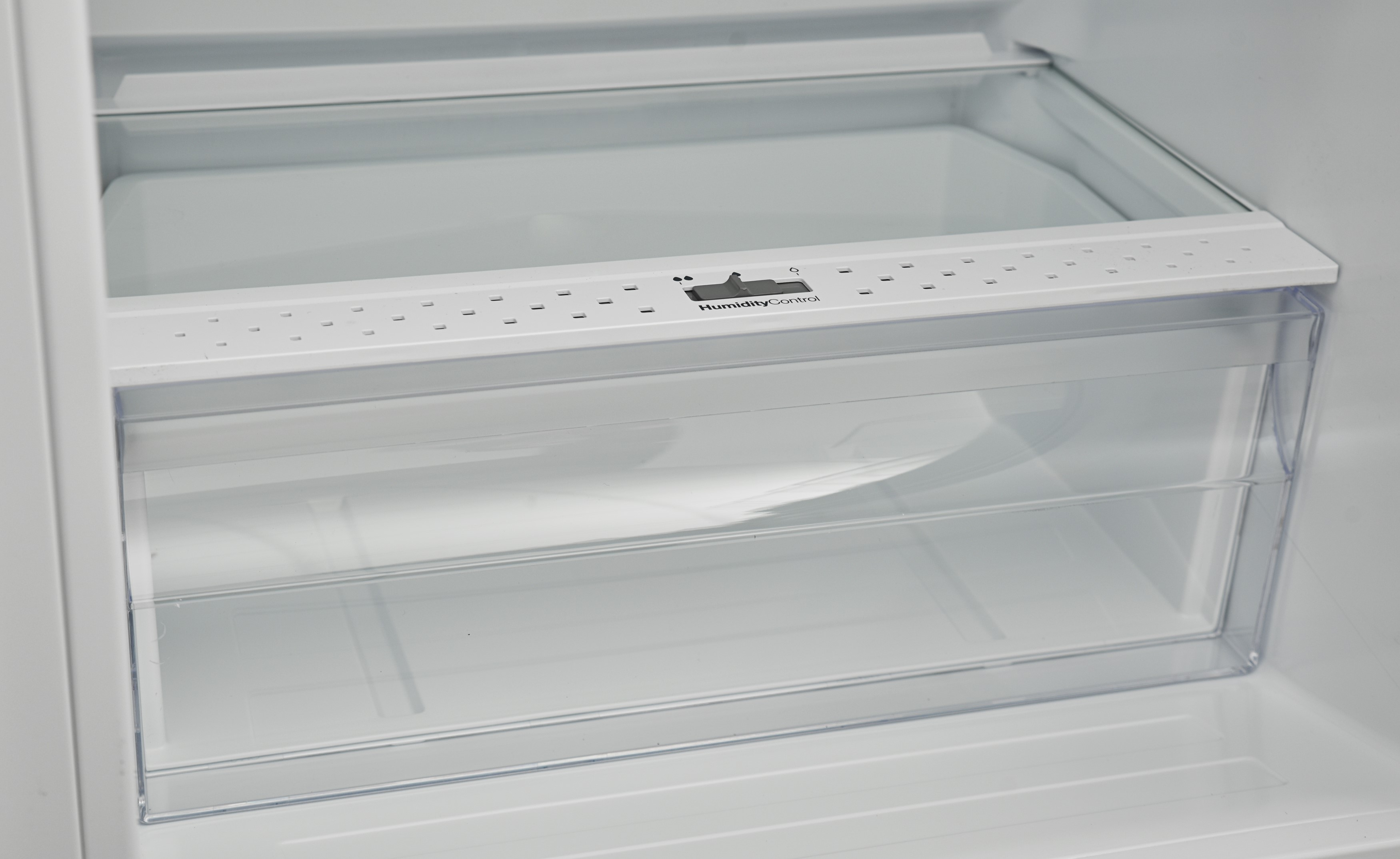 Inside a refrigerator: a clear drawer with a white frame.