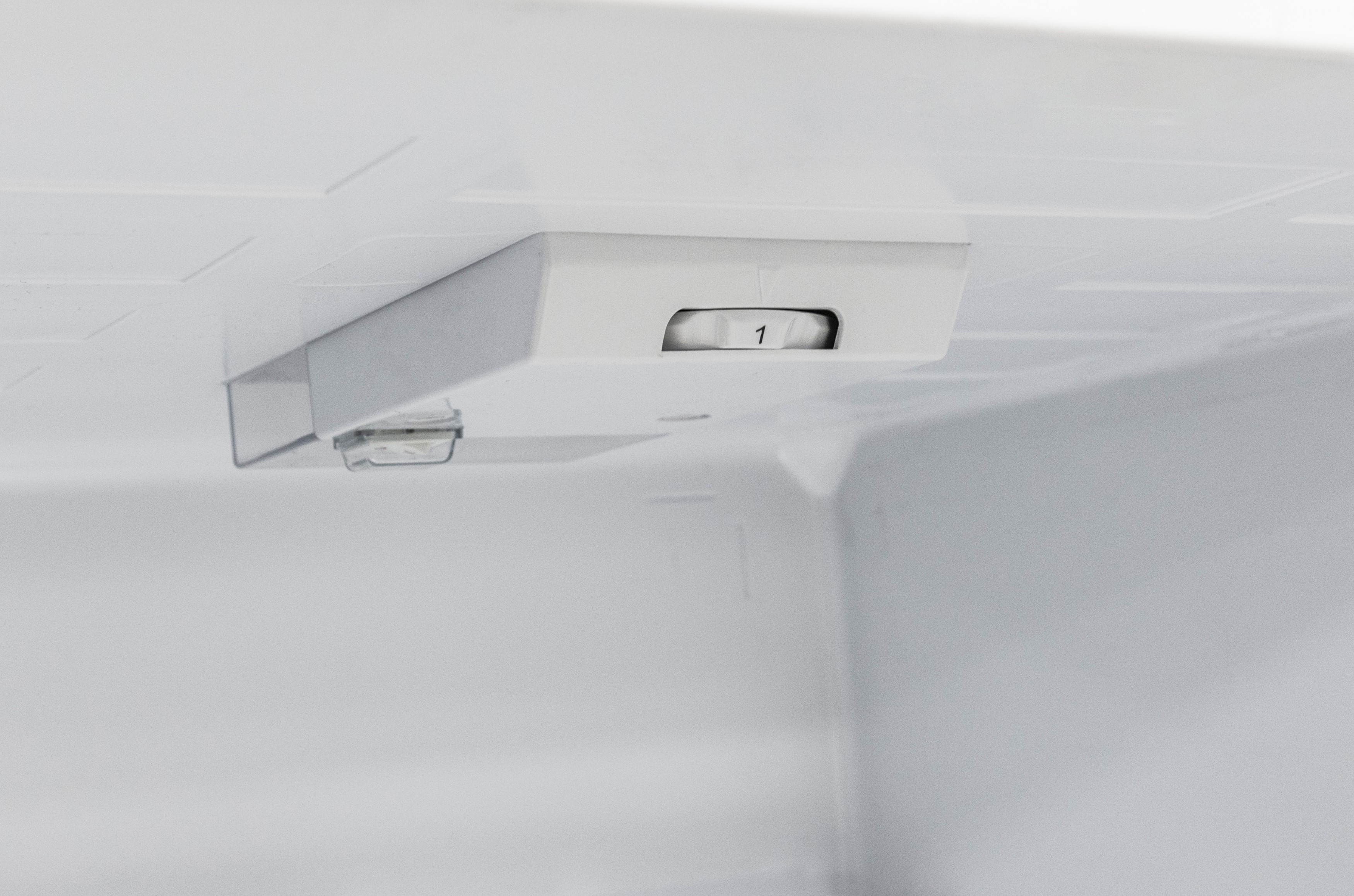 A white interior shot of a refrigerator with a white control panel.