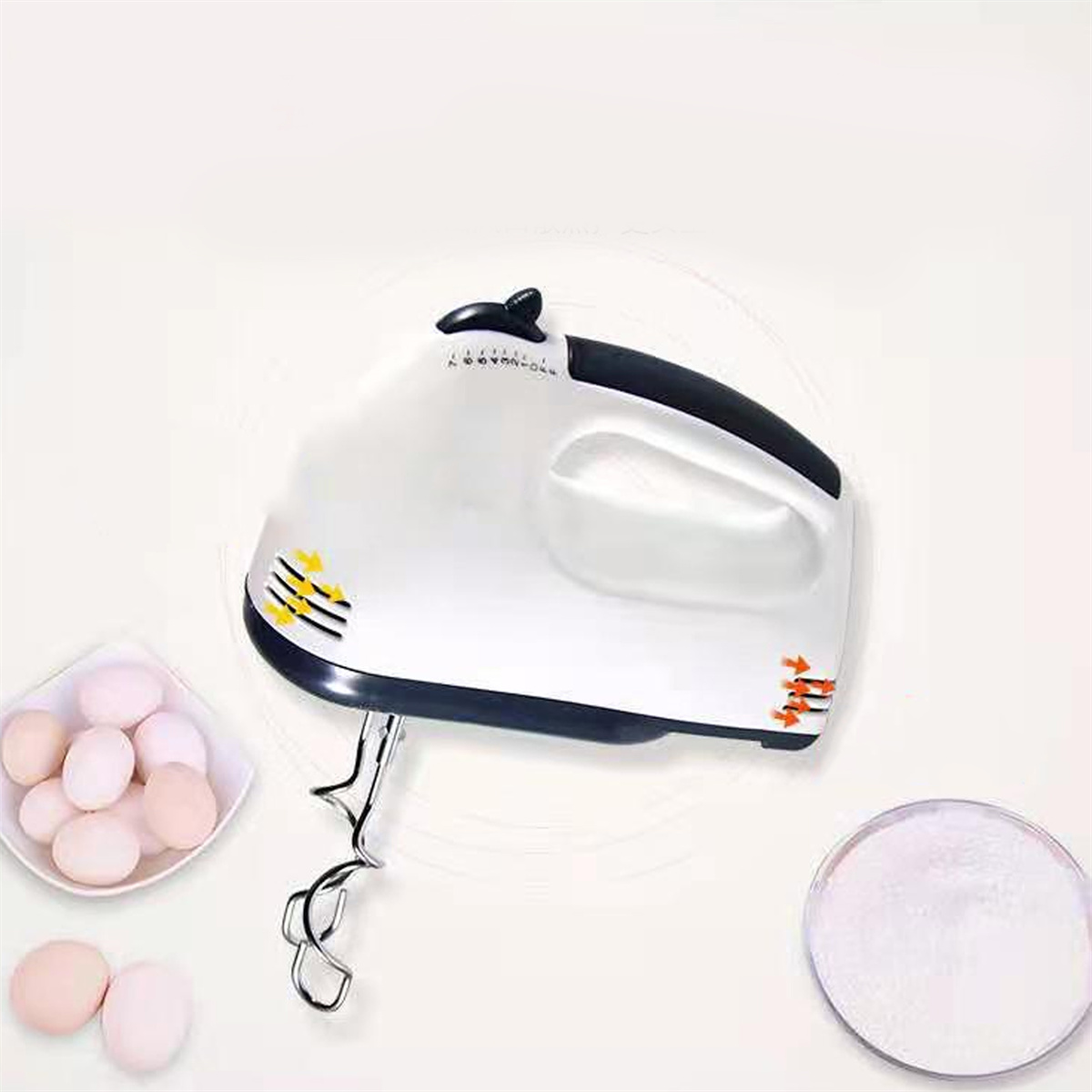 Weißer Handmixer, Eier und Mehl auf weißem Hintergrund. Der Mixer hat schwarze Akzente.