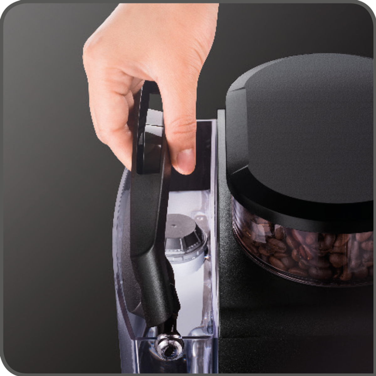 Una mano apre un contenitore di una macchina da caffè, mostrando il vano acqua e chicchi di caffè.