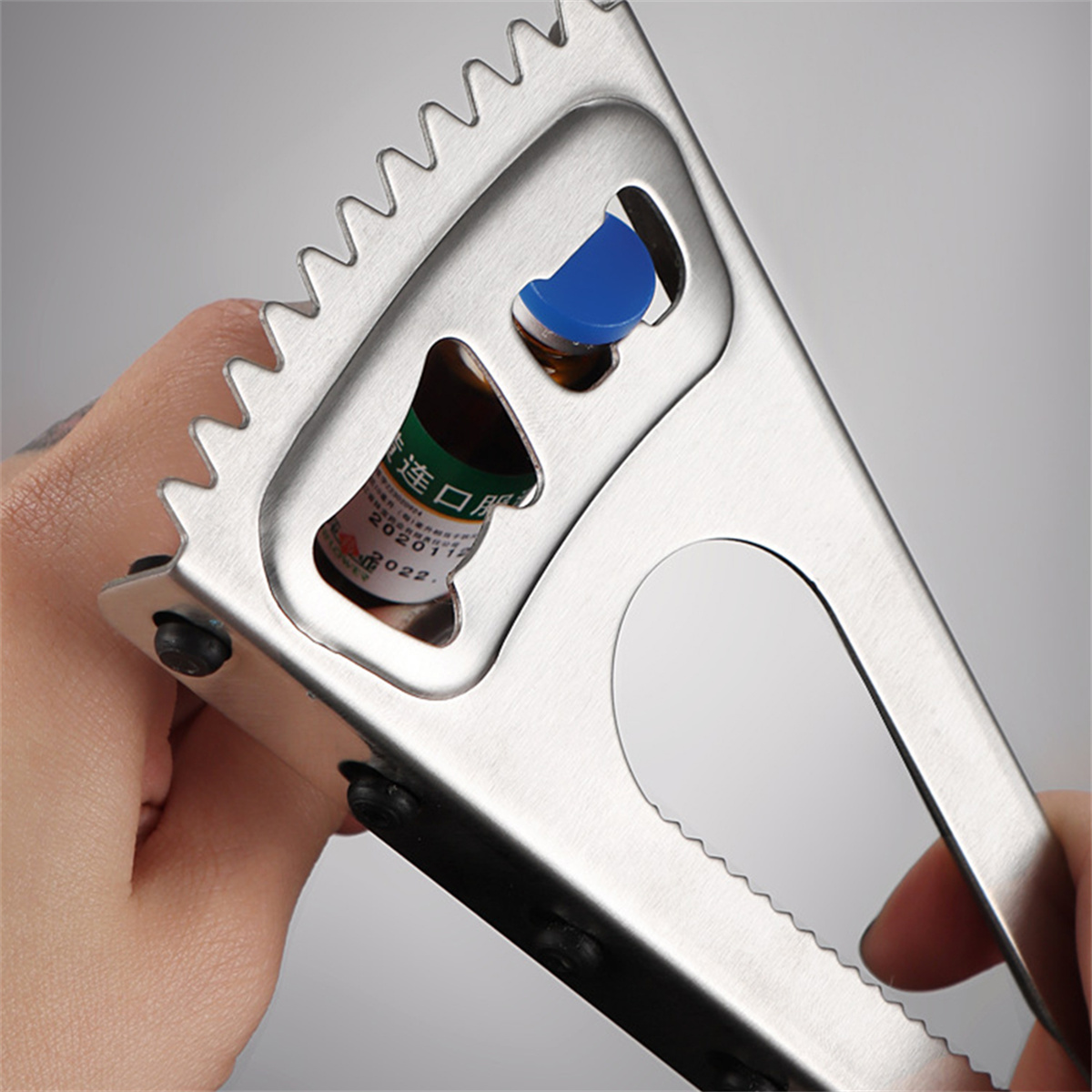 Edelstahl-Multitool öffnet eine Flasche mit blauem Verschluss.