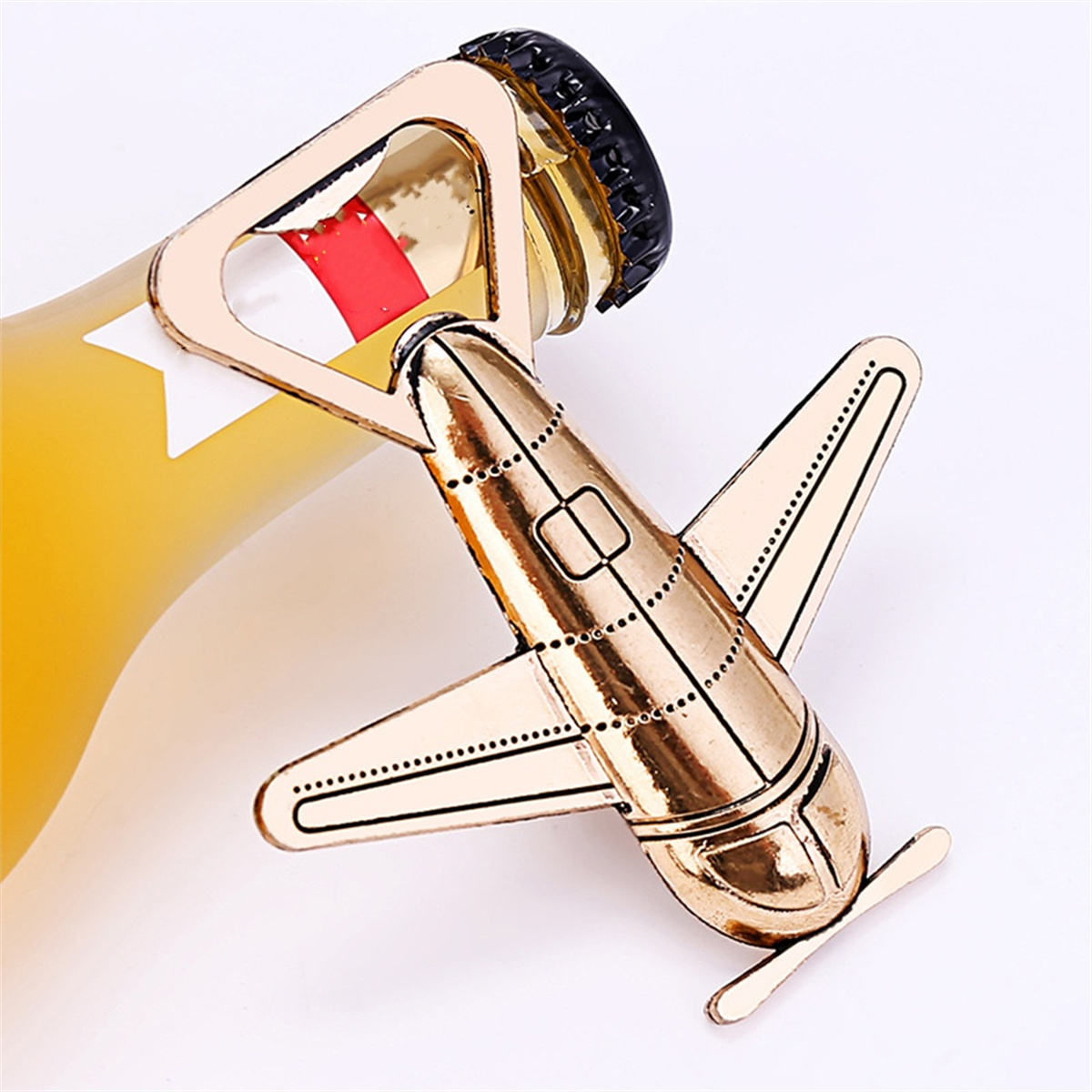 Goldener Flugzeug-Flaschenöffner. Der Öffner ist an einer Flasche mit gelber Flüssigkeit befestigt.