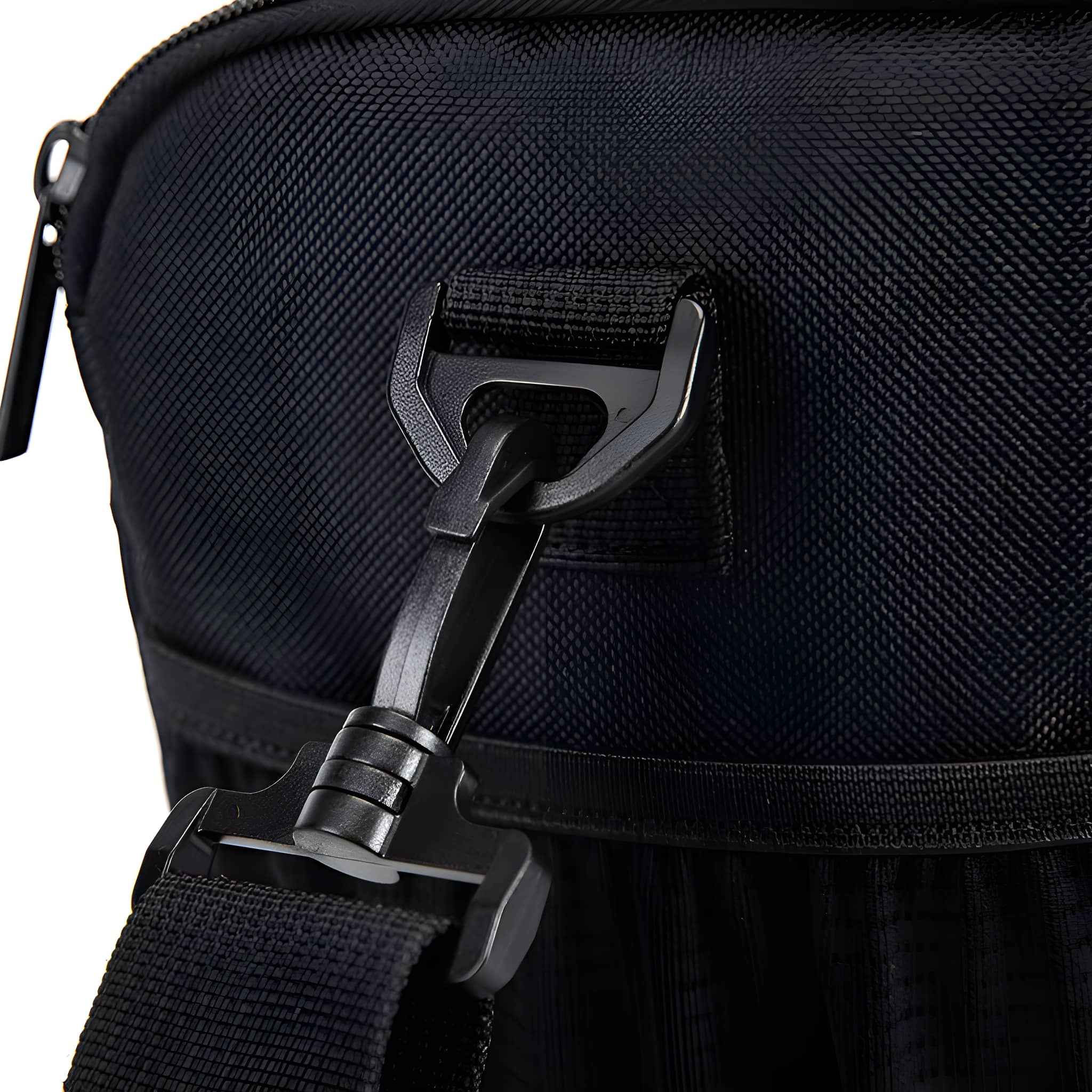 Nahaufnahme einer schwarzen Tasche mit schwarzem Riemen und Verschluss. Die Tasche hat eine strukturierte Oberfläche.