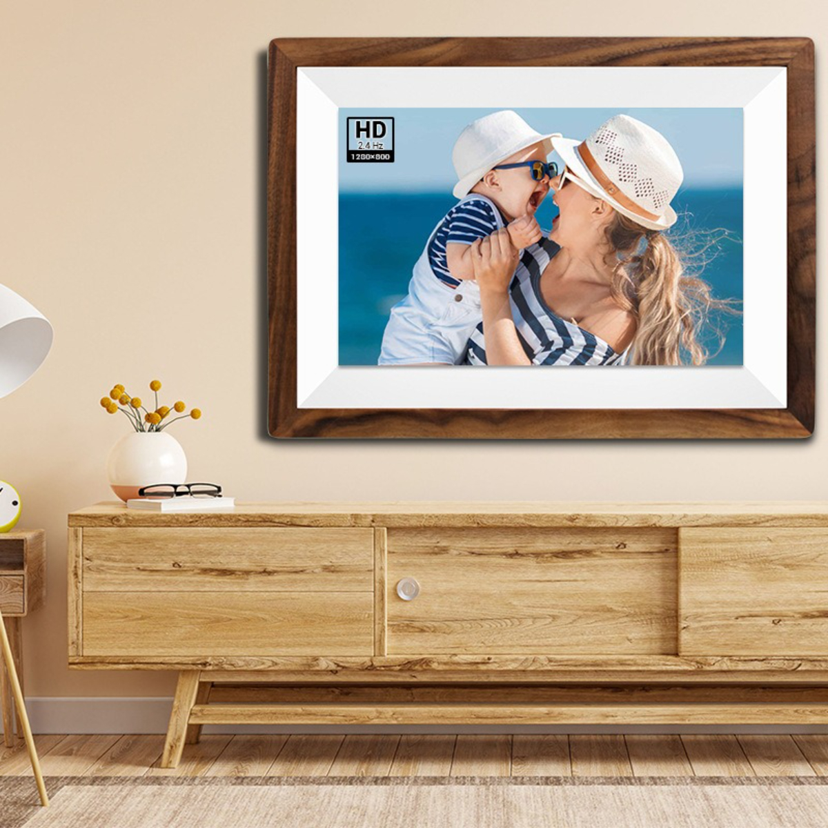 Ein gerahmtes Bild an einer Wand zeigt eine Mutter und ein Kind. Der Rahmen ist braun, die Wand beige.