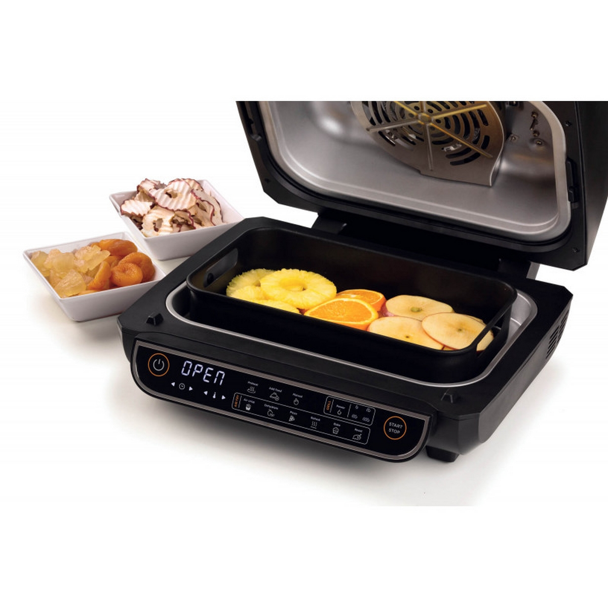 Otwarty czarny grill Ninja Foodi z różnymi potrawami, w tym owocami, i wentylatorem w środku.