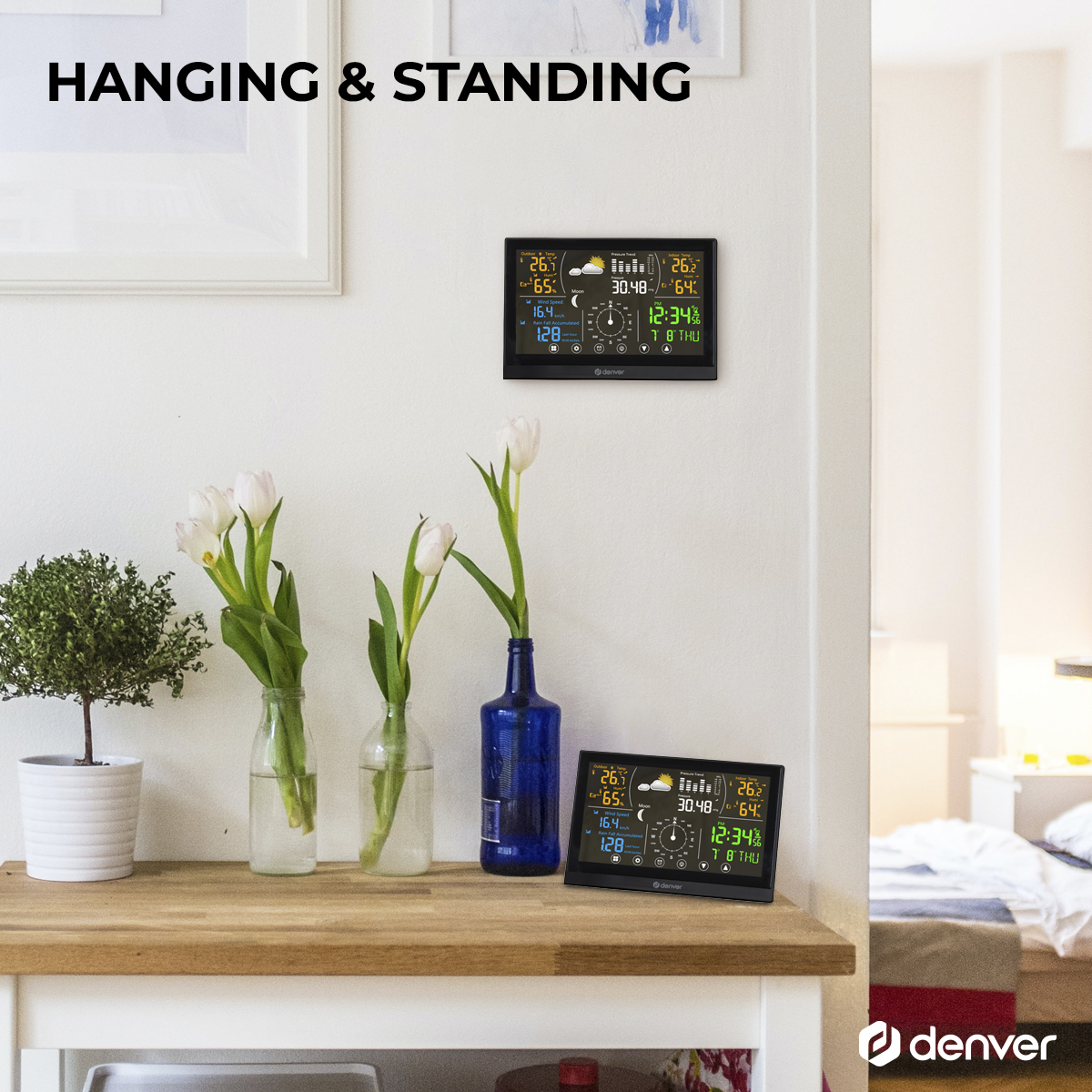 Two digital weather stations, one on a shelf with flowers, one mounted on the wall.