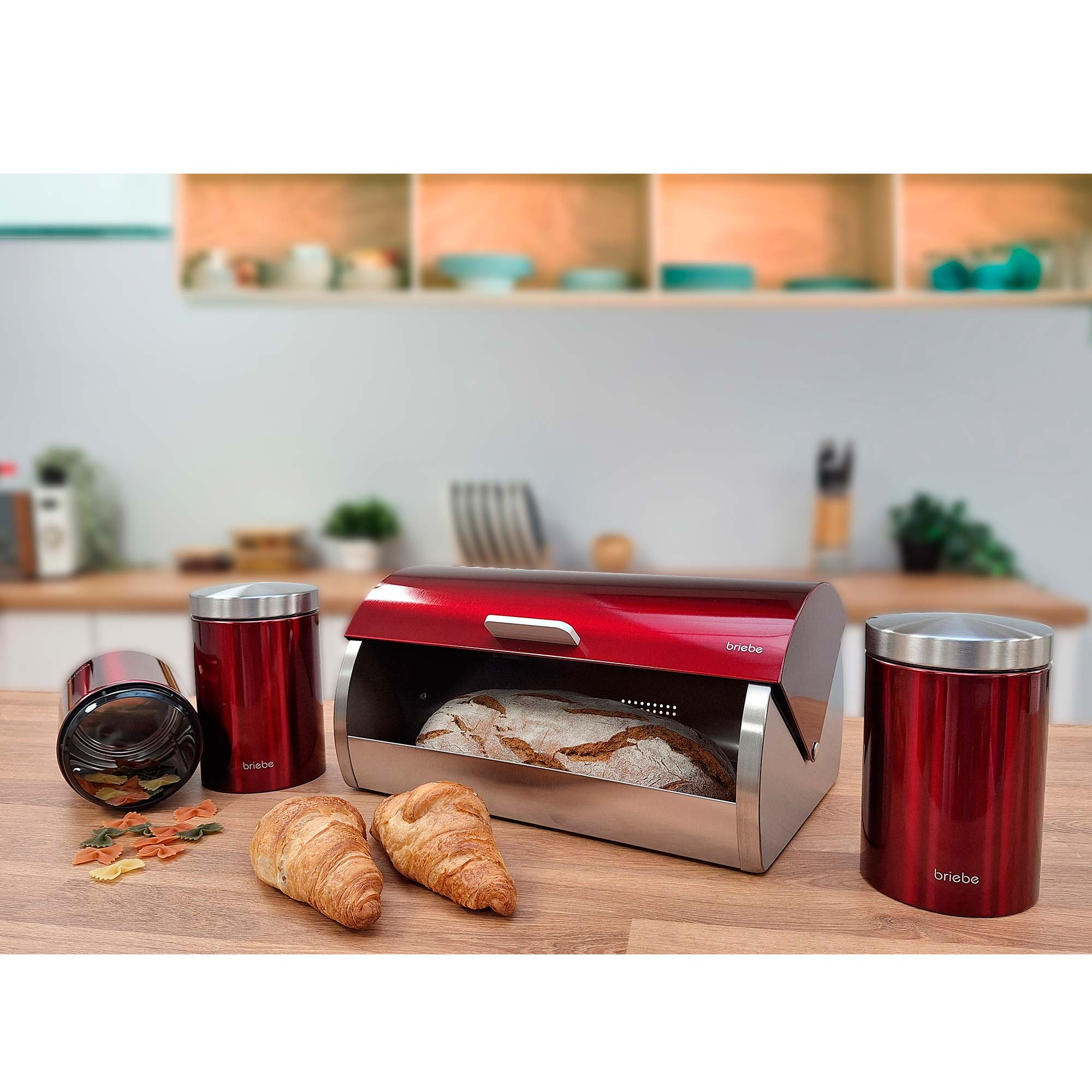 Rote Brotbox mit Brot, zwei rote Behälter auf Holztisch.