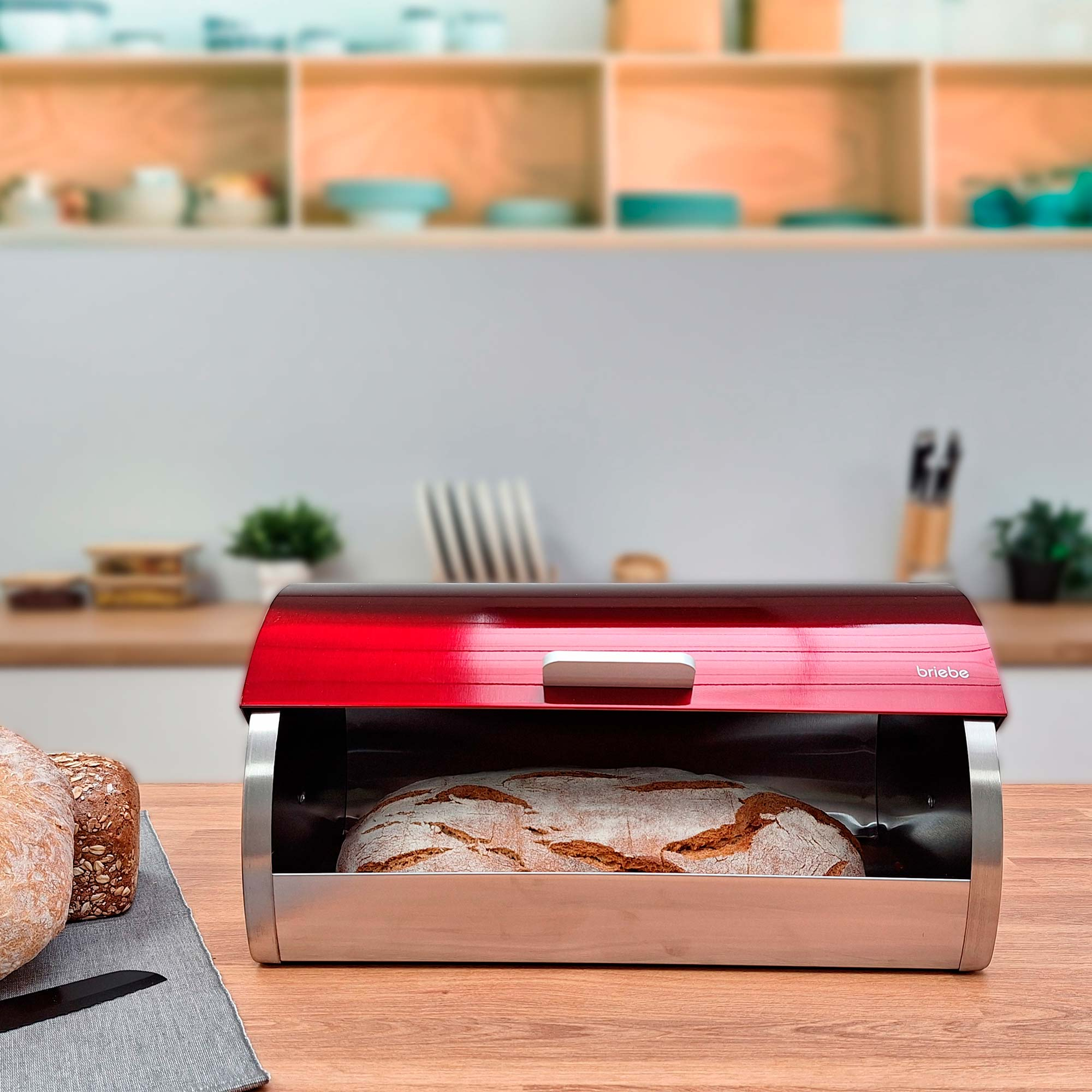 Rote Brotdose mit klarer Front, die ein Brot zeigt. Küchenhintergrund.