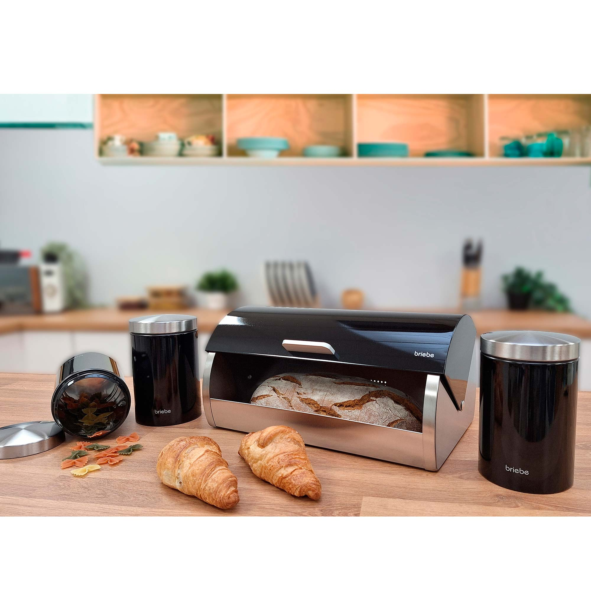 Schwarze und silberne Brotdose mit Brot, Croissants und Lebensmittelbehältern.
