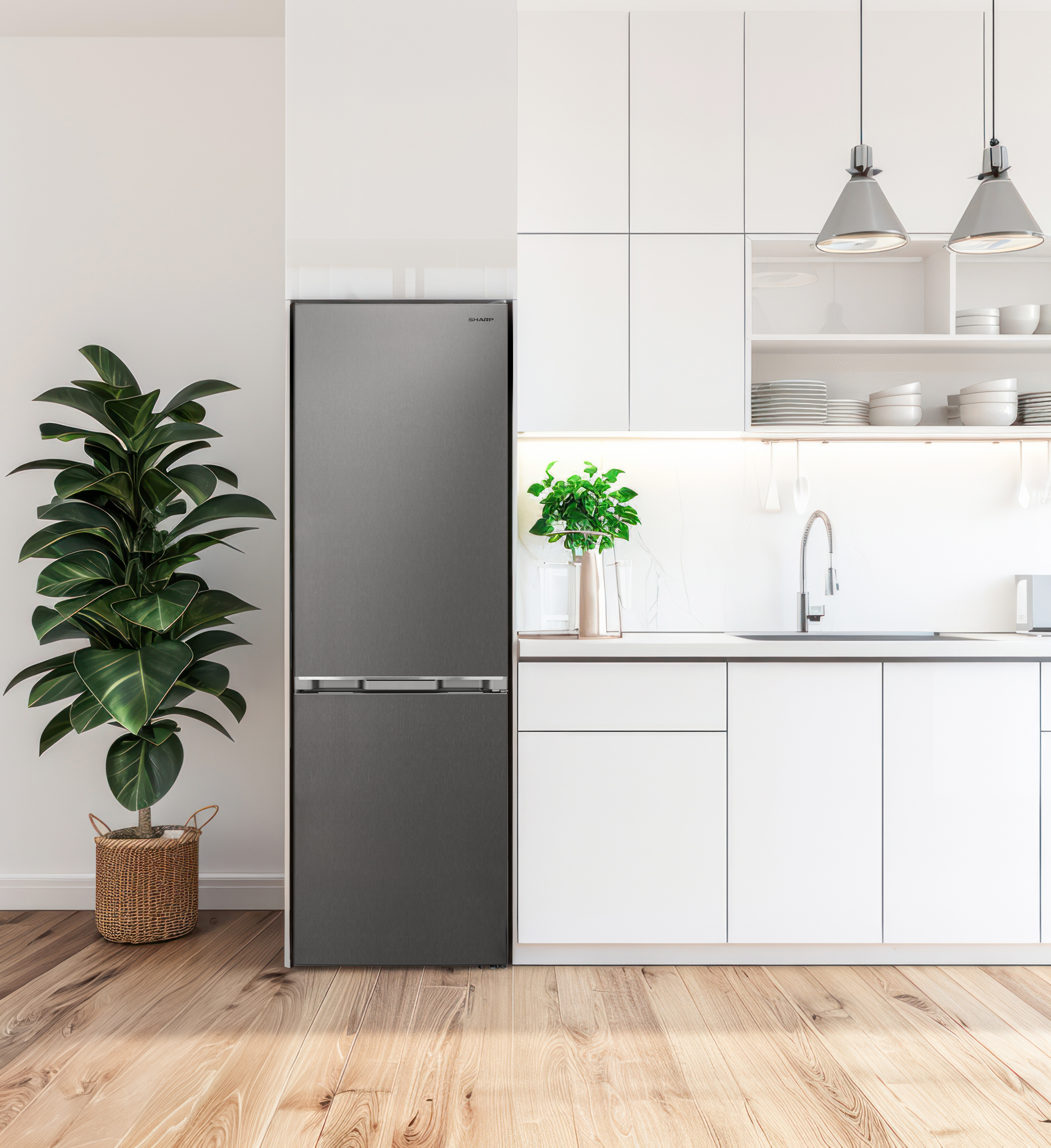 Moderne keuken met grijze koelkast, houten vloer en hoge potplant.