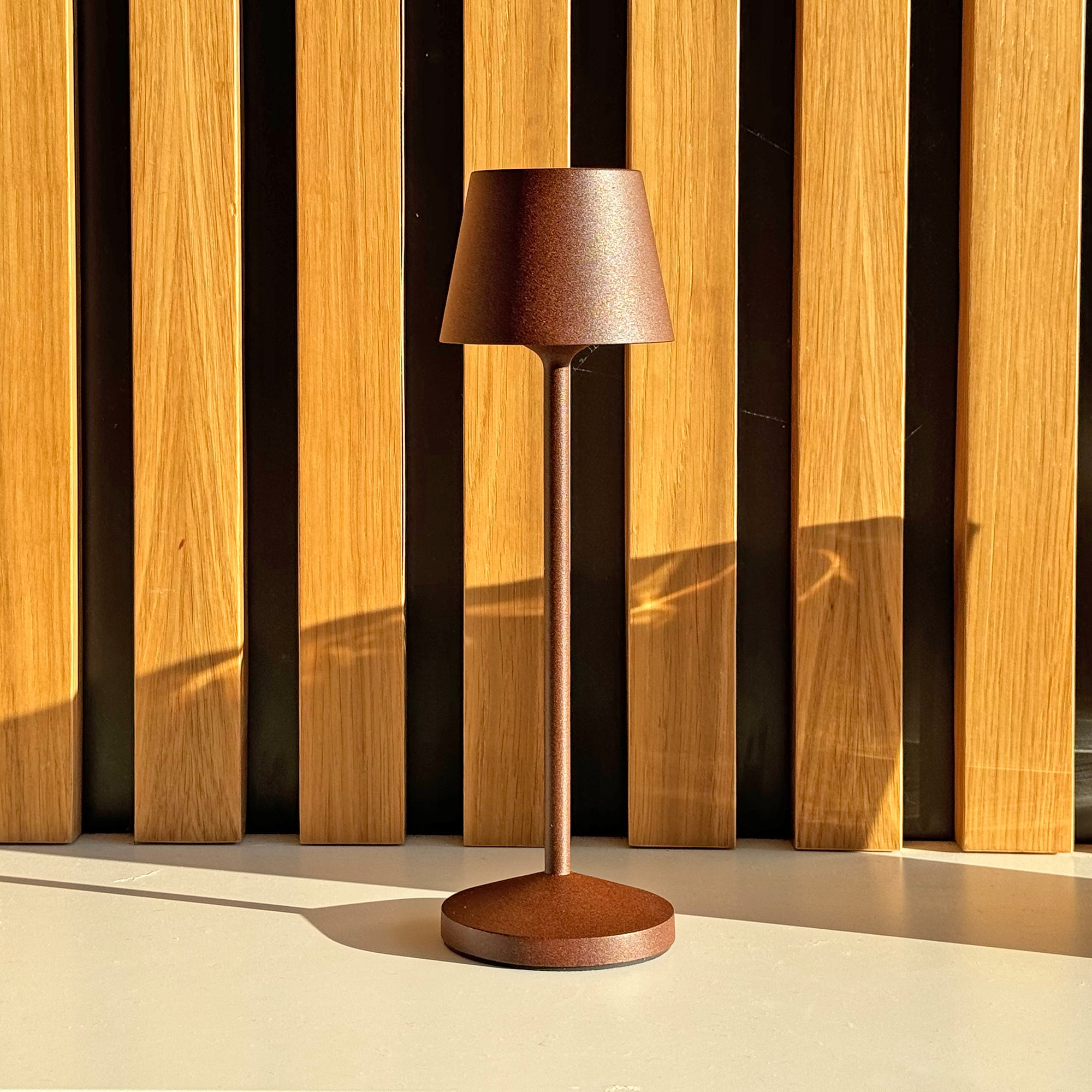 Bronzene Tischlampe mit braunem Lampenschirm, Holz Hintergrund.