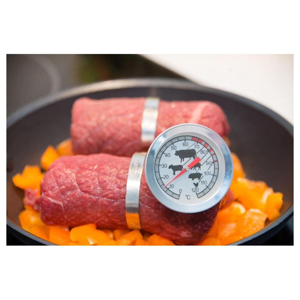 Zwei Rindfleischröllchen in einer Pfanne mit Paprika. Ein Fleischthermometer befindet sich in der Pfanne.