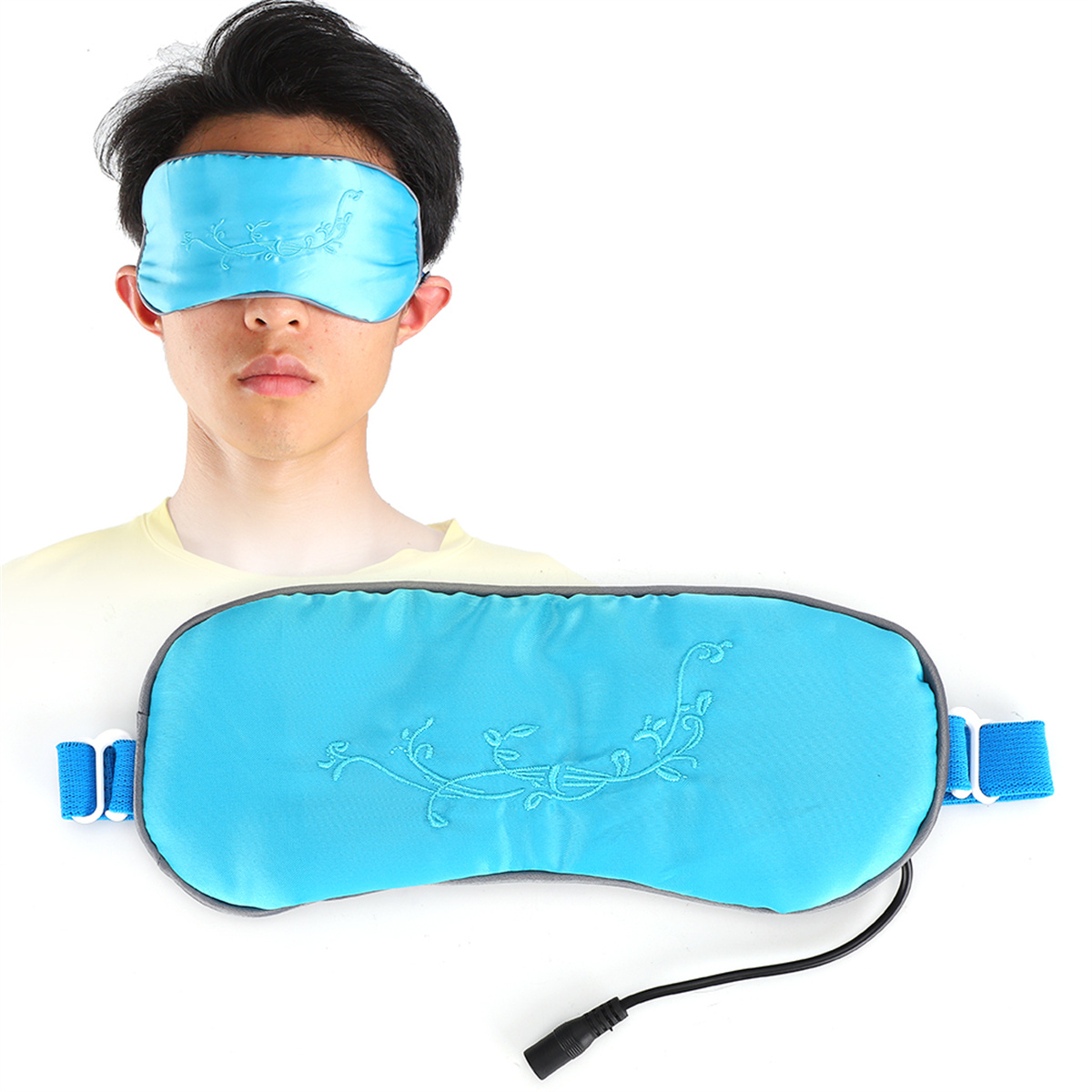 Eine Person trägt eine blaue Augenmaske, eine größere blaue Maske liegt auf der Brust.
