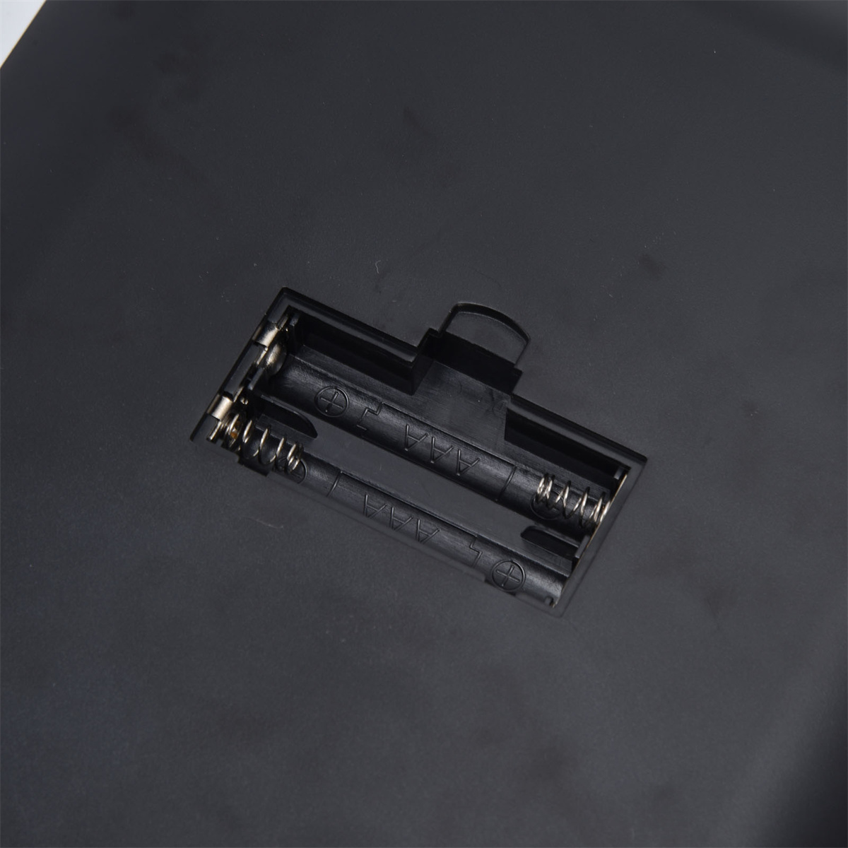 Schwarzes Geräteinnere mit zwei Batterieschächten. Die Schlitze haben Federn.