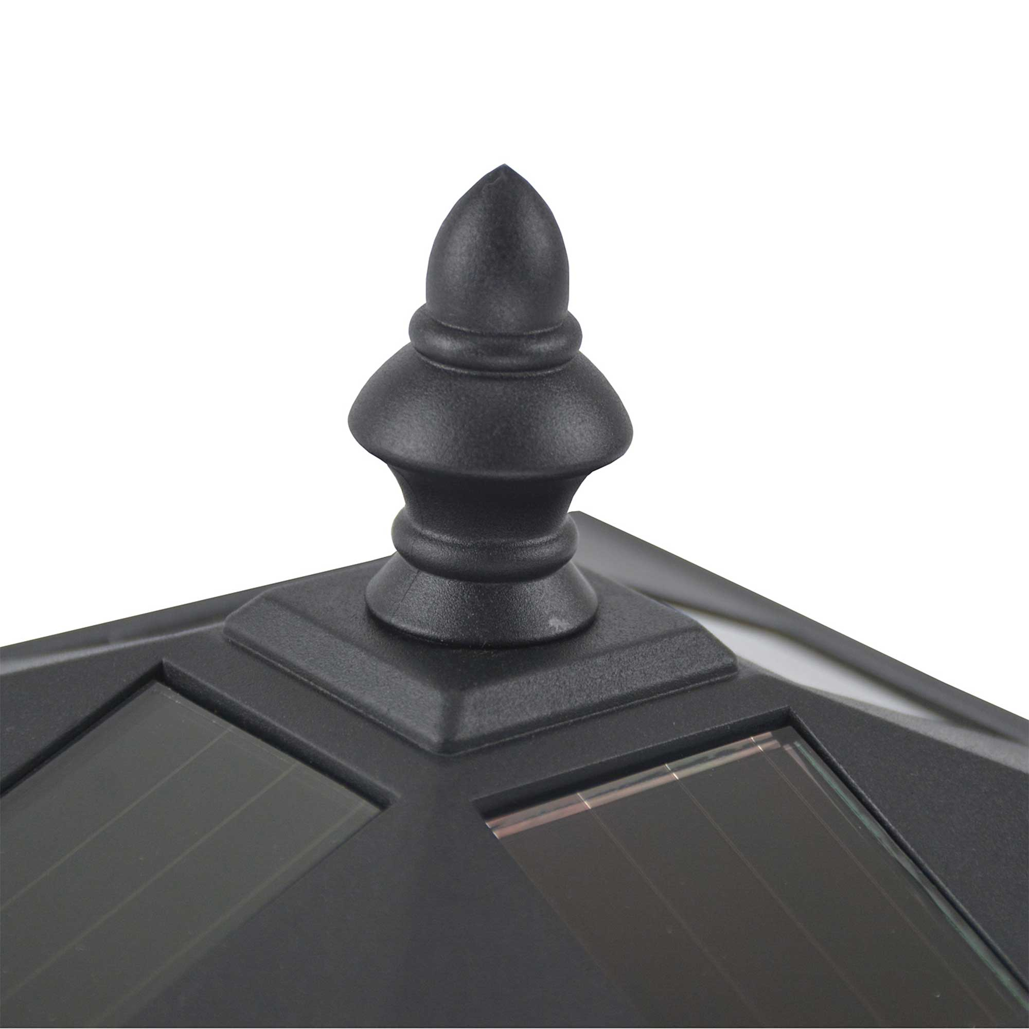 Un primer plano de una luz solar decorativa negra con una parte superior puntiaguda y paneles solares.
