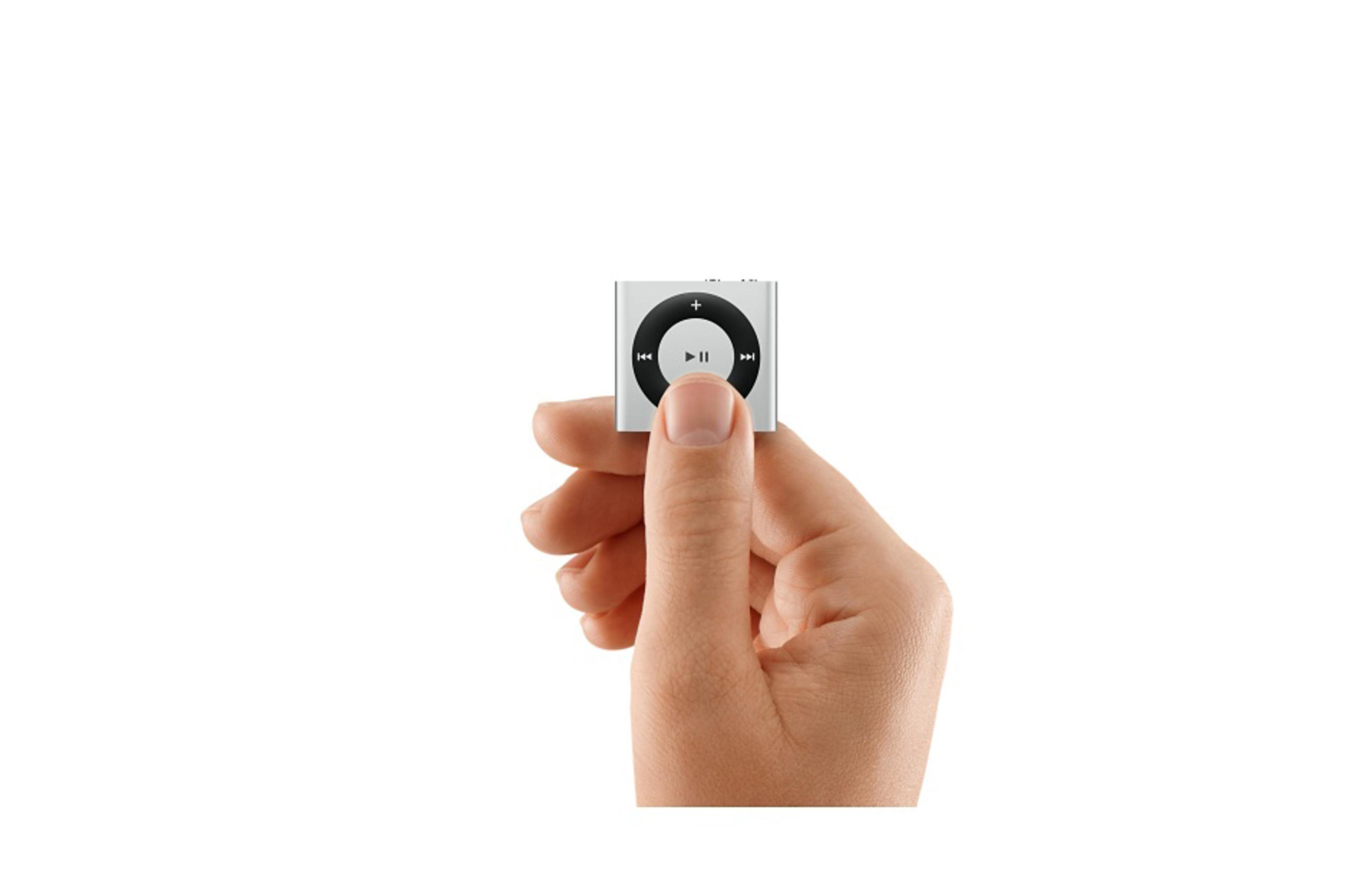 Ein silberner iPod Shuffle wird von einer Hand vor weißem Hintergrund gehalten. Er hat einen zentralen Play/Pause-Knopf.
