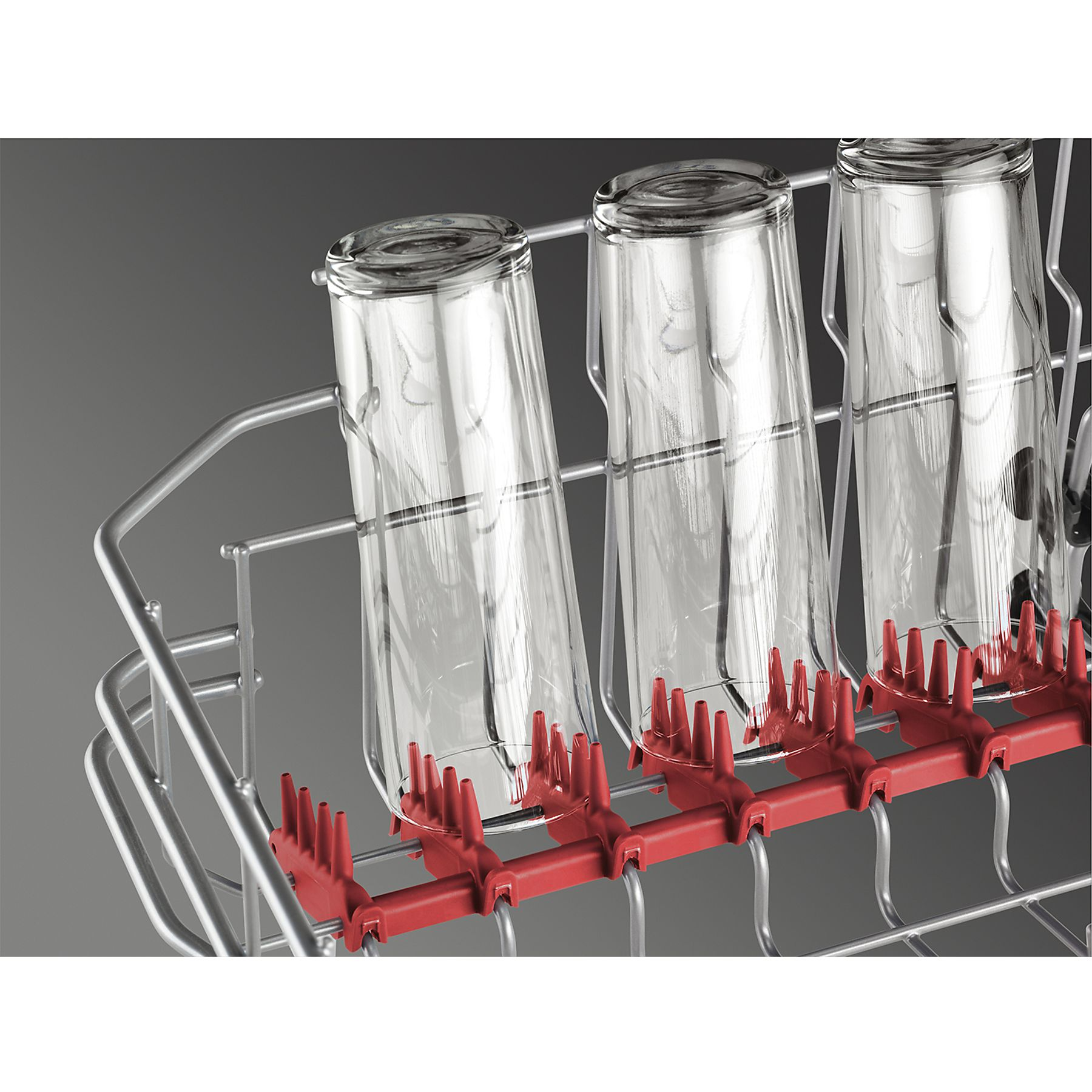 Rejilla de lavavajillas con vasos. Se ven tres vasos, sujetos por soportes rojos, sobre un fondo gris.