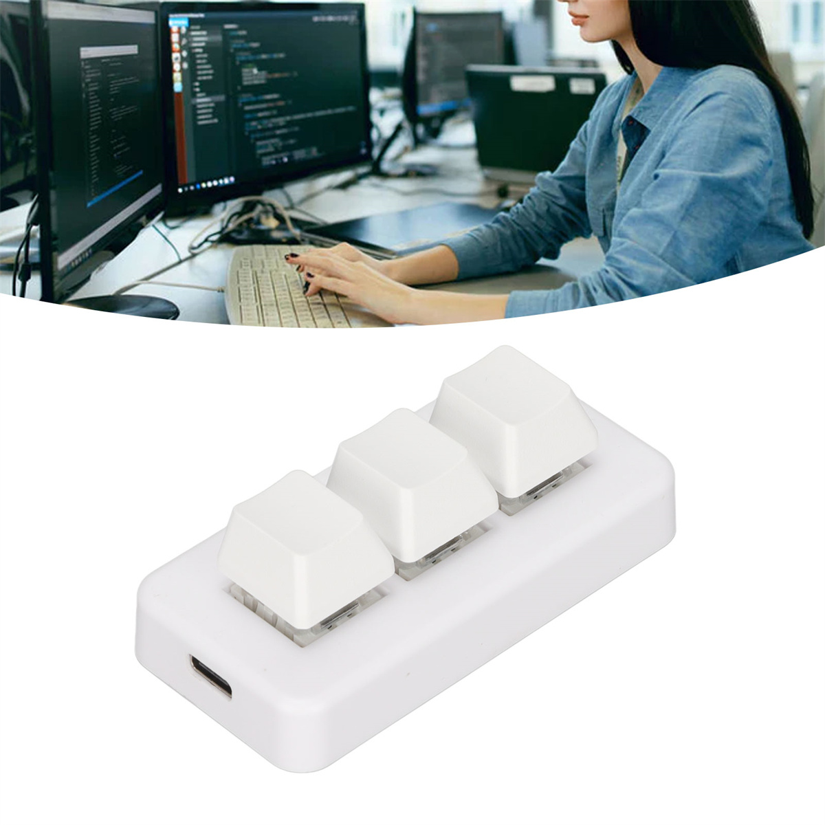 Weiße Tastatur mit drei großen quadratischen Tasten. Eine Person tippt im Hintergrund auf einem Computer.