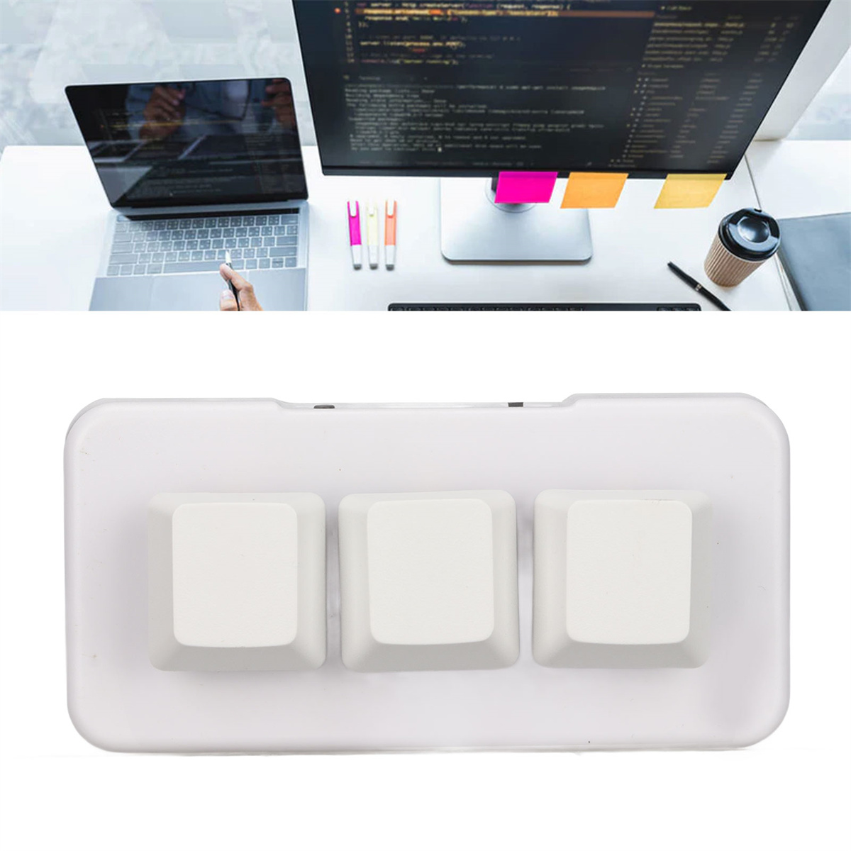Weiße Tastatur mit drei großen Tasten, Computer im Hintergrund.