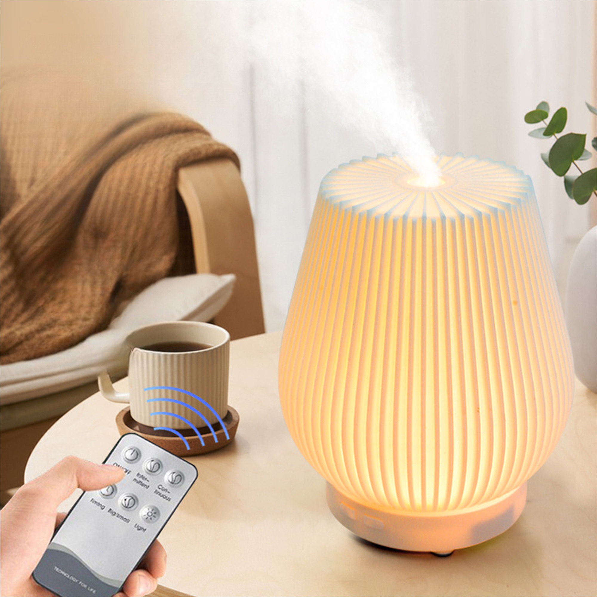 Weiß-goldener Luftbefeuchter mit Dampfausstoß. Eine Tasse und Fernbedienung stehen auf einem Holztisch.
