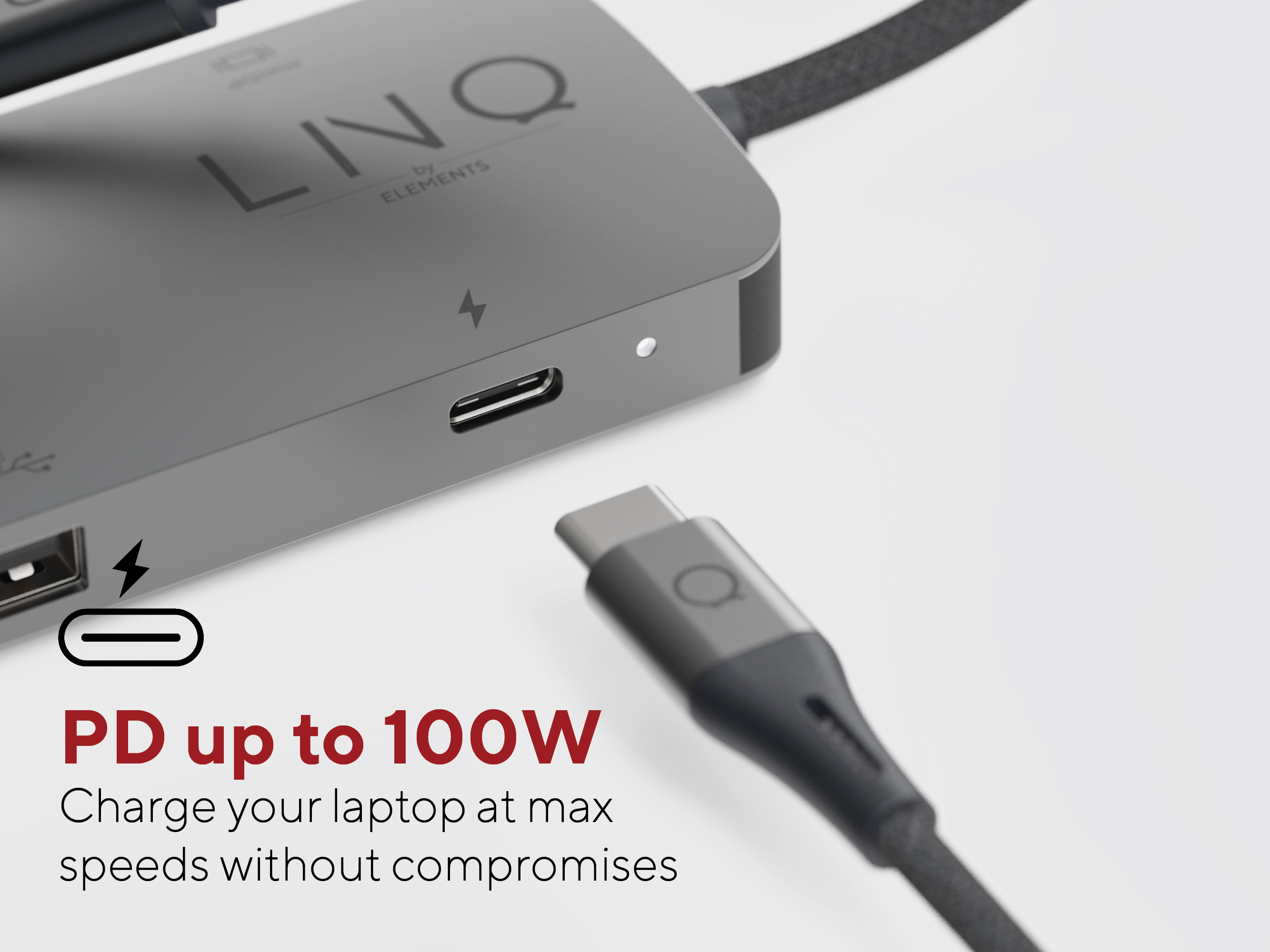 Primo piano di un hub USB-C grigio con un cavo di ricarica collegato.