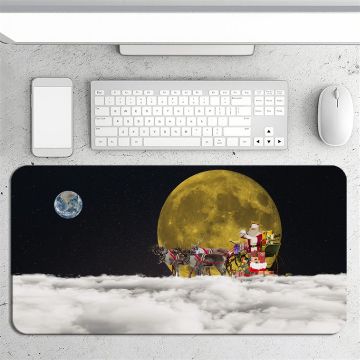 Weihnachtsschlitten mit Rentieren über Wolken, Mondhintergrund. Tastatur, Telefon, Maus auf Tisch.