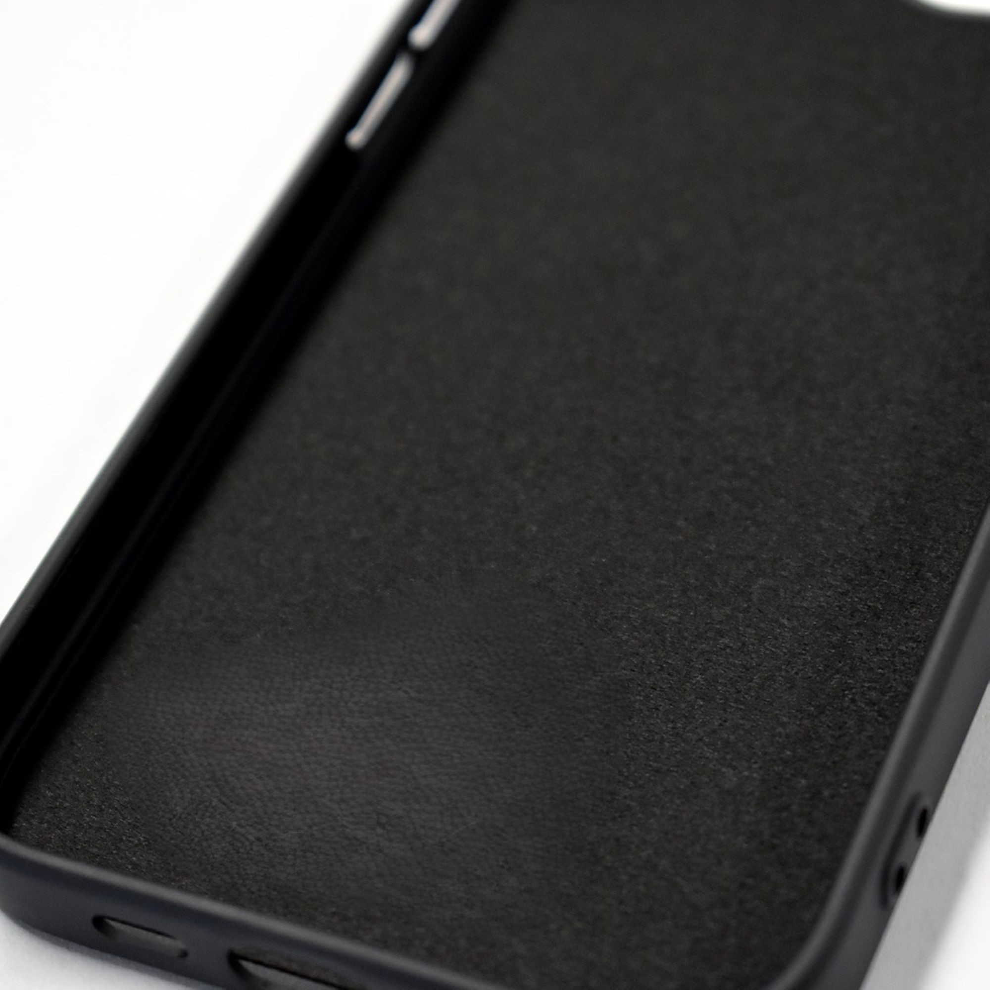 Gros plan de l'intérieur d'une coque de téléphone noire, montrant la texture et les contours.