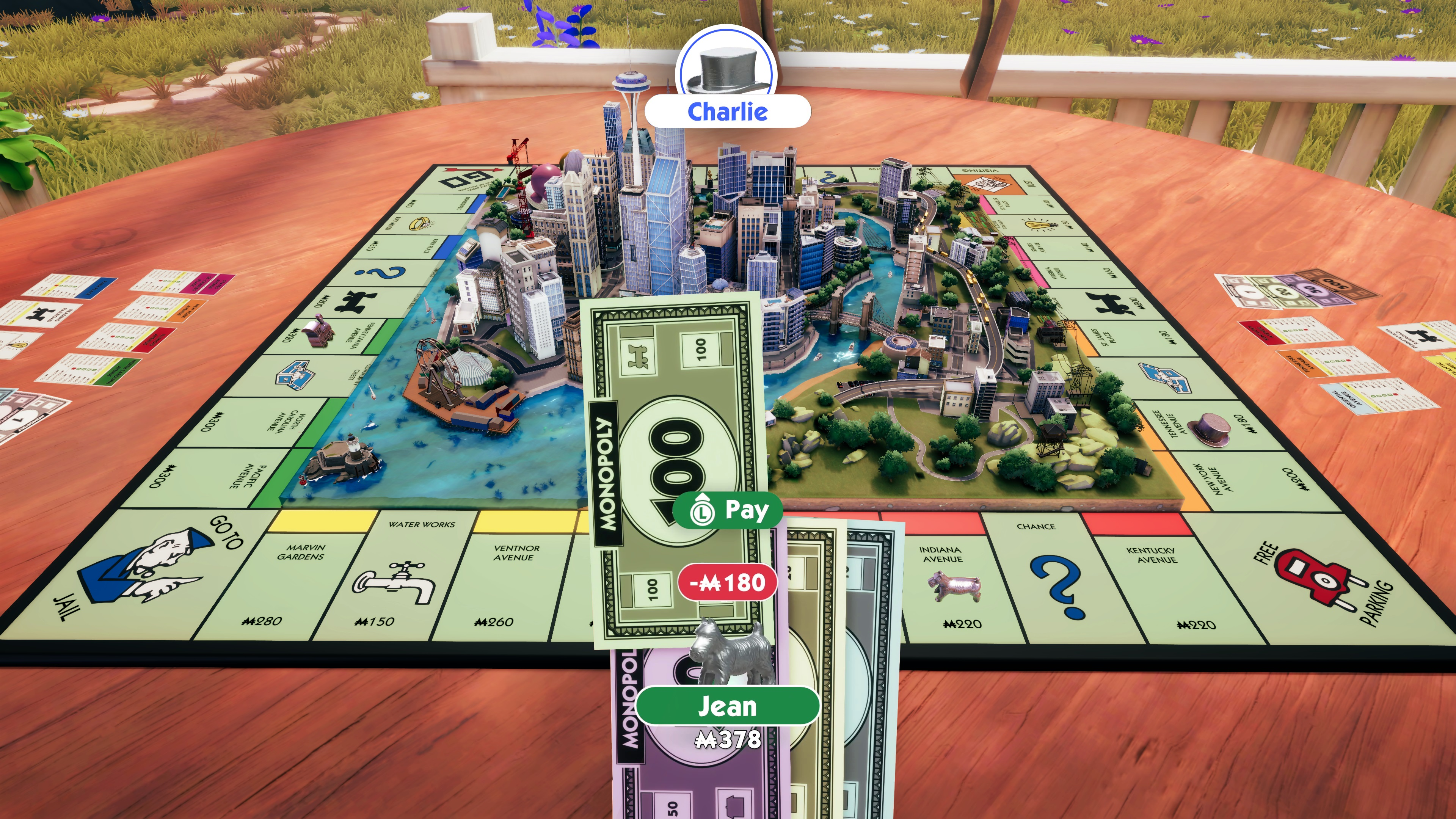 Tabellone Monopoly, con edifici e denaro. Due giocatori, Charlie e Jean, stanno giocando.