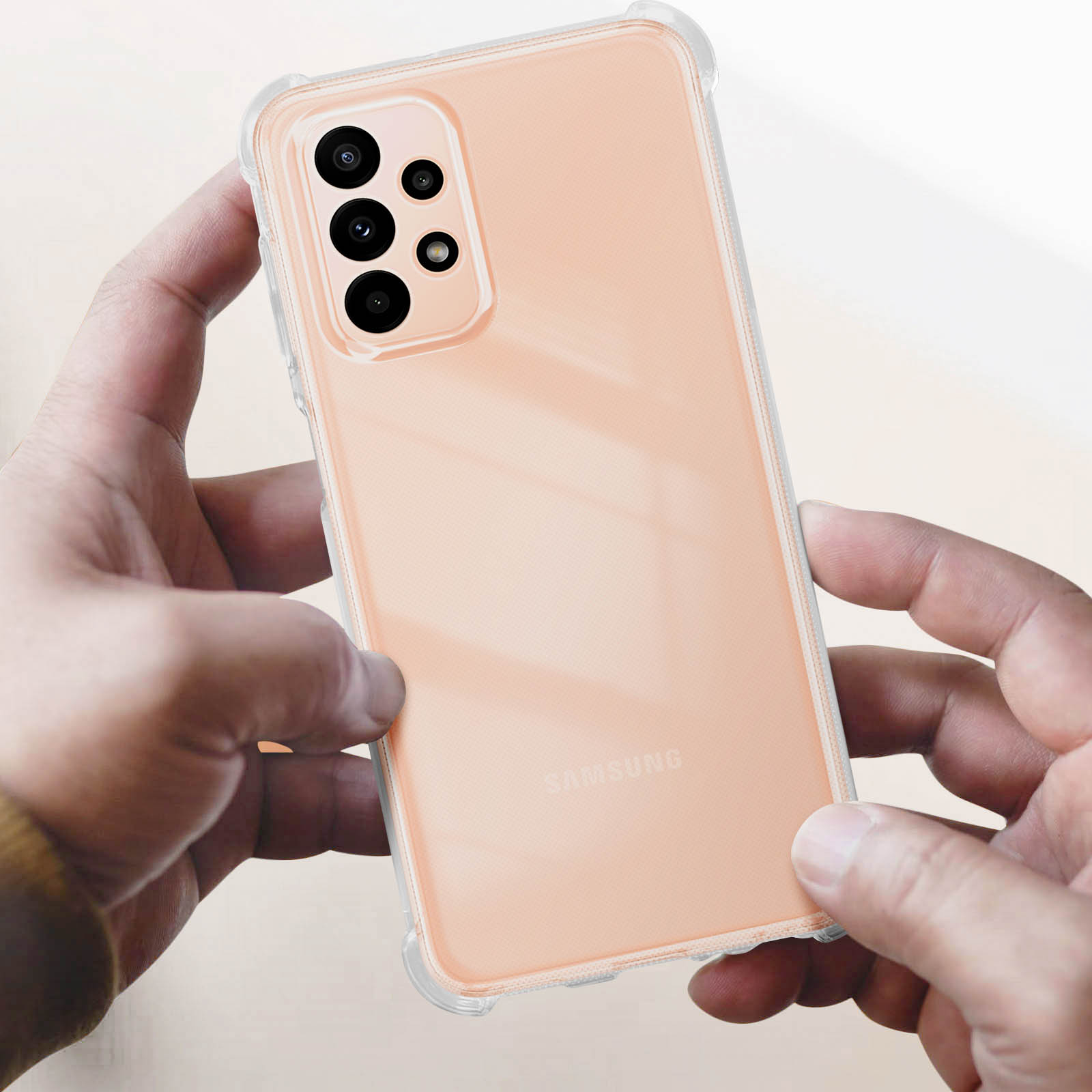 Telefono in una custodia trasparente. Mani che tengono un telefono. Custodia arancione e sfondo bianco.