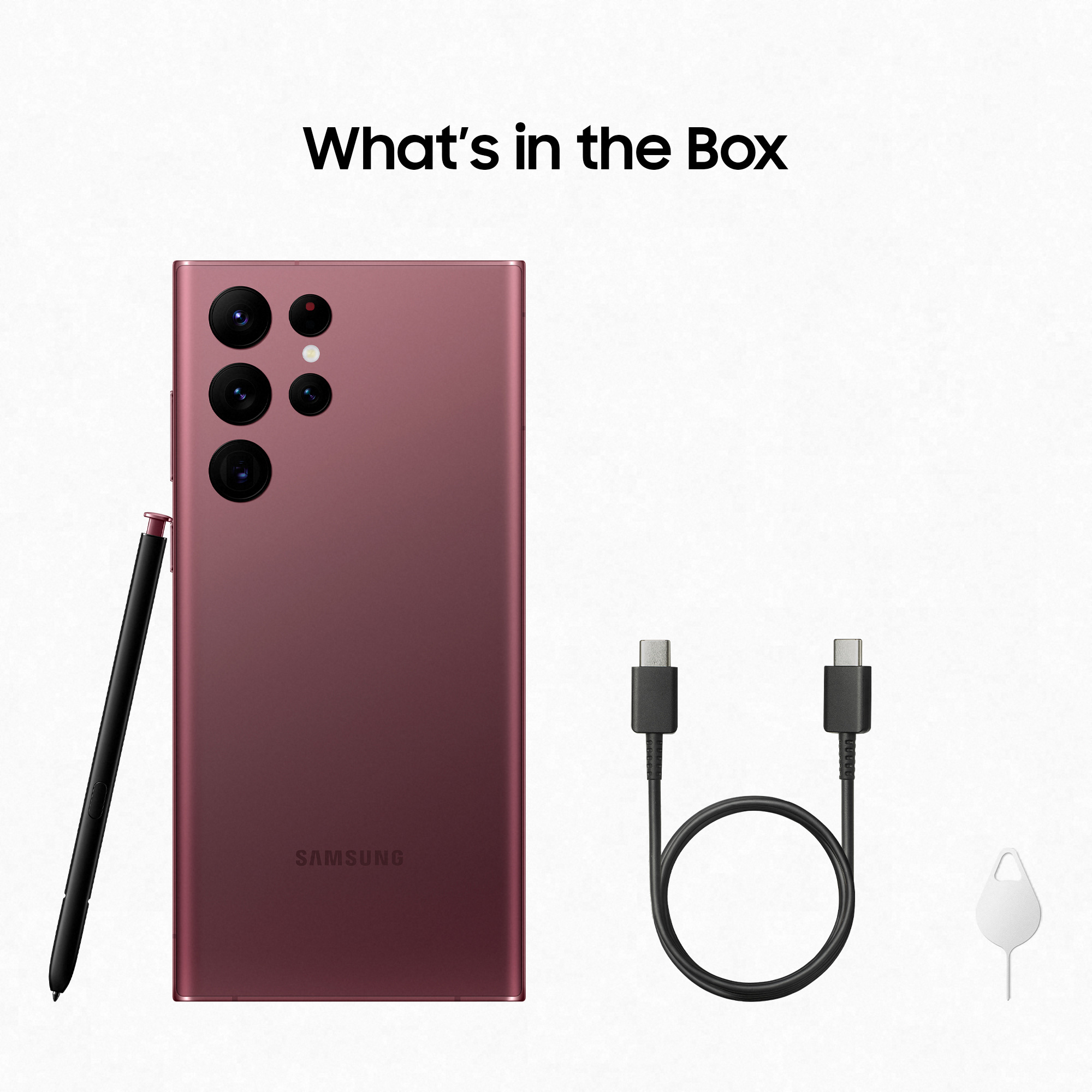 Pudełko z telefonem, rysikiem i kablami. Telefon jest różowy, z wieloma aparatami.