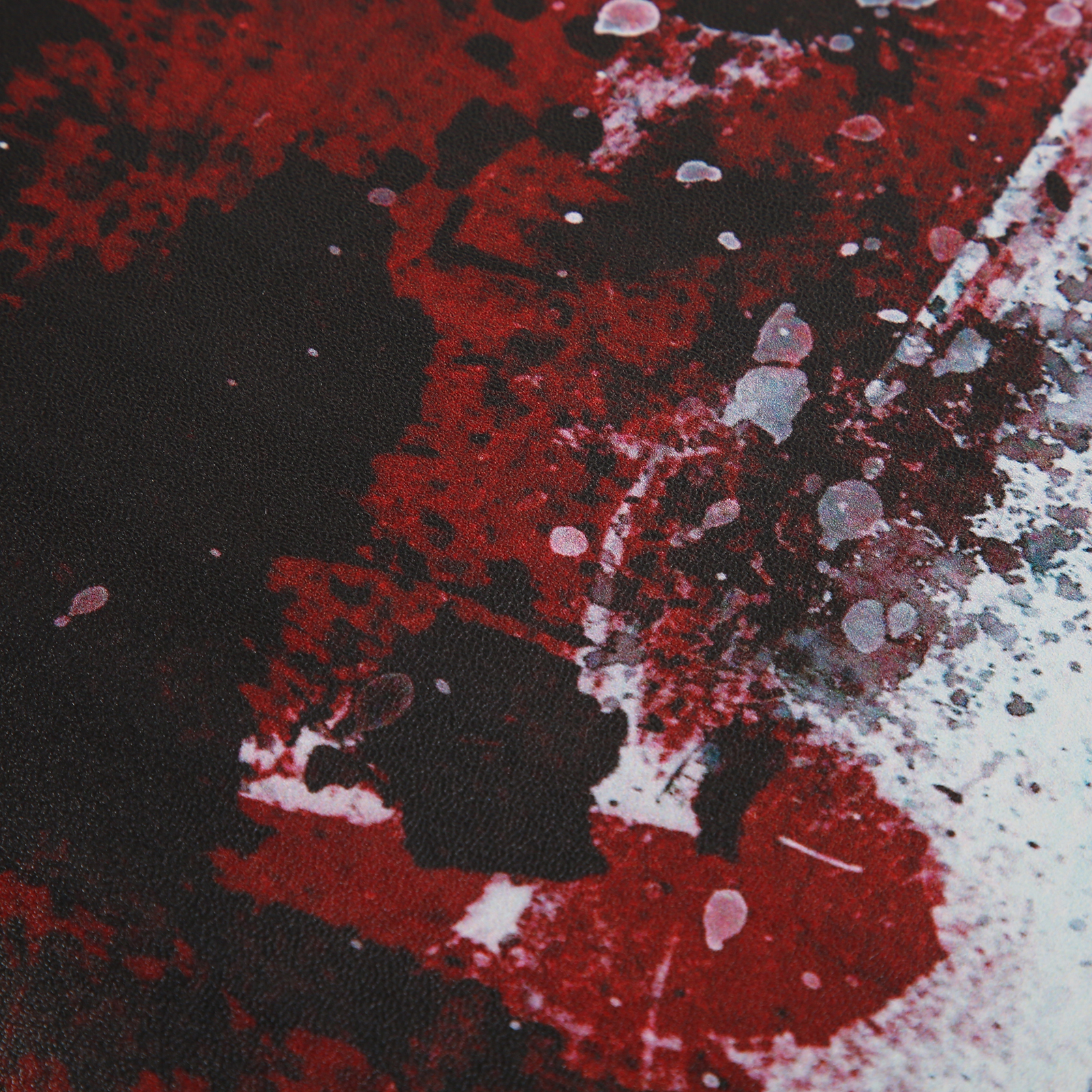 Abstrakte Kunst mit roten und schwarzen Farbspritzern auf weißem Hintergrund. Einige weiße Punkte vorhanden.