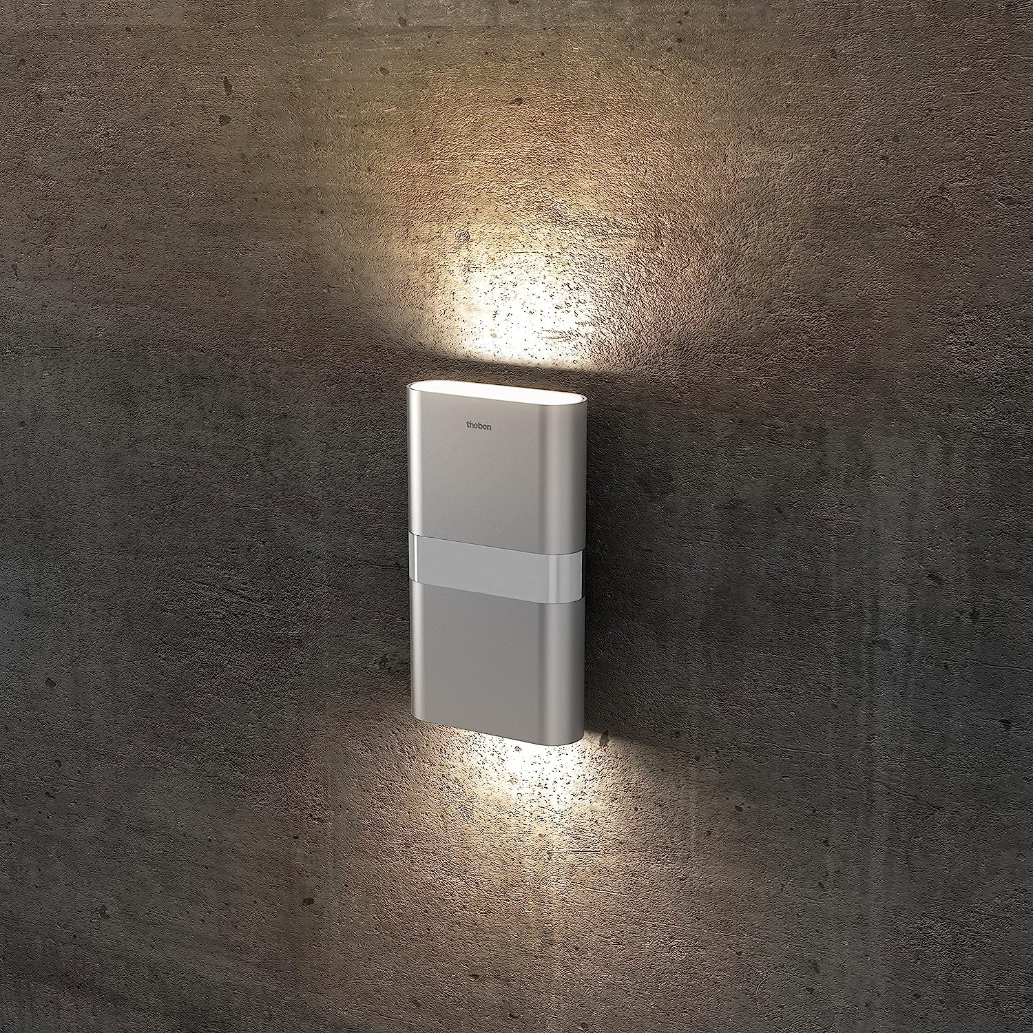 Eine silberne Wandleuchte an einer strukturierten grauen Wand, beleuchtet.