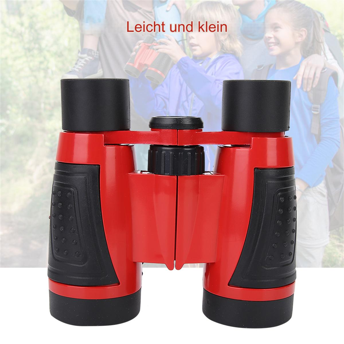 Rotes und schwarzes Fernglas. Zwei Kinder im Hintergrund.
