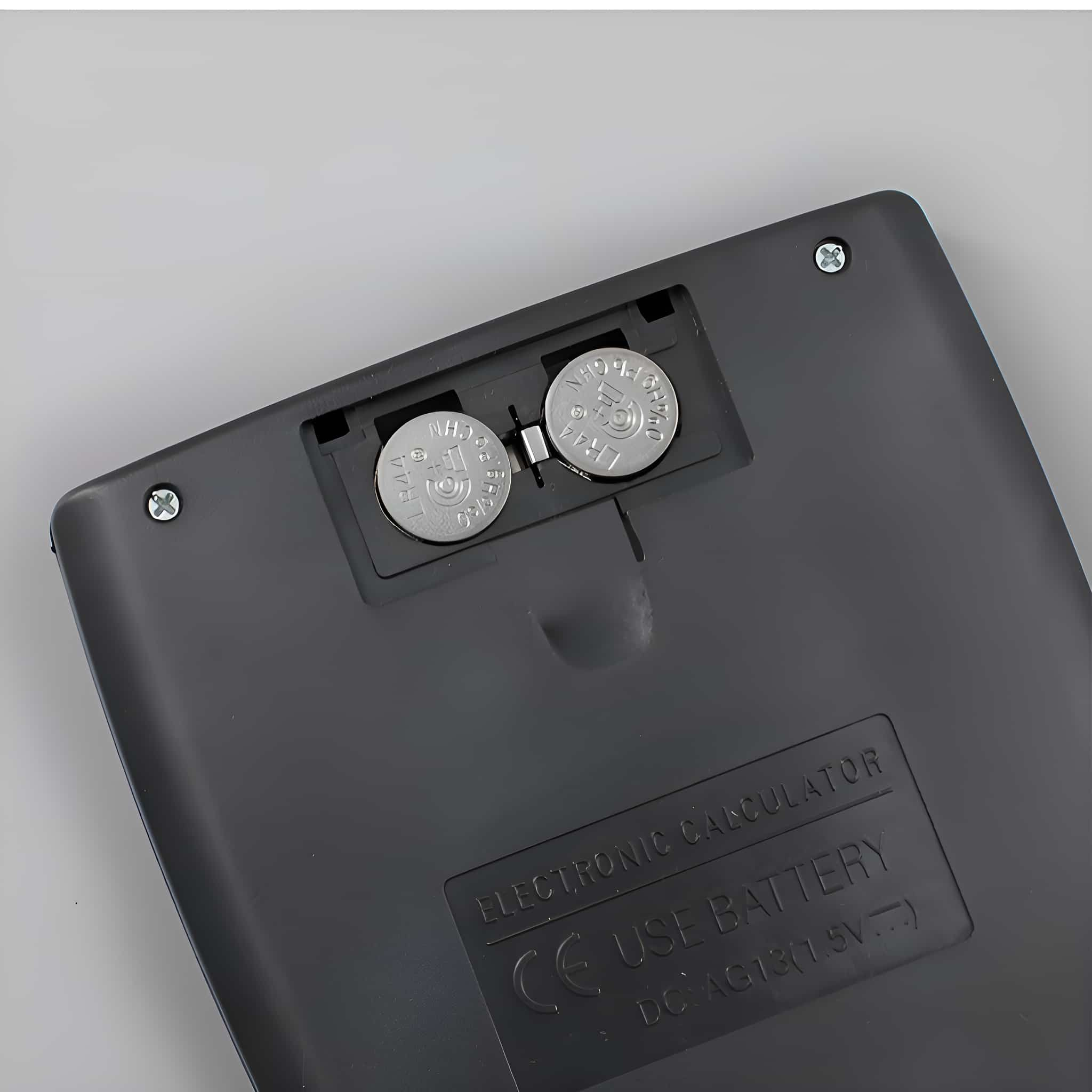Die Rückseite eines schwarzen elektronischen Taschenrechners. Zwei Batterien sind eingesetzt, mit einem Batteriefach-Etikett.