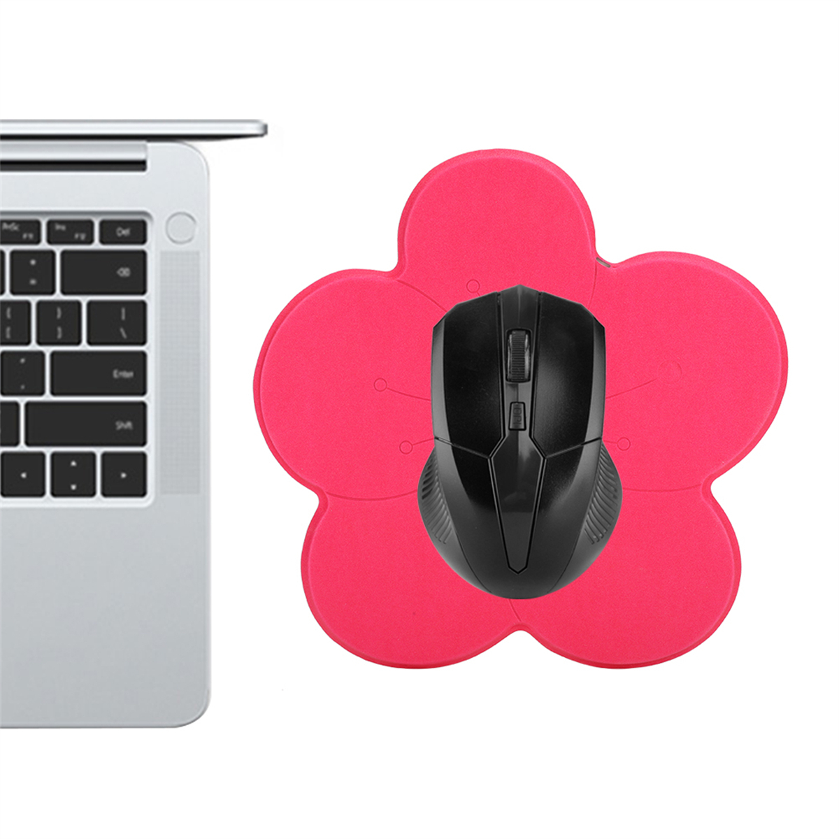 Eine schwarze Maus auf einem rosa blütenförmigen Mousepad, neben einem Laptop auf weißem Hintergrund.