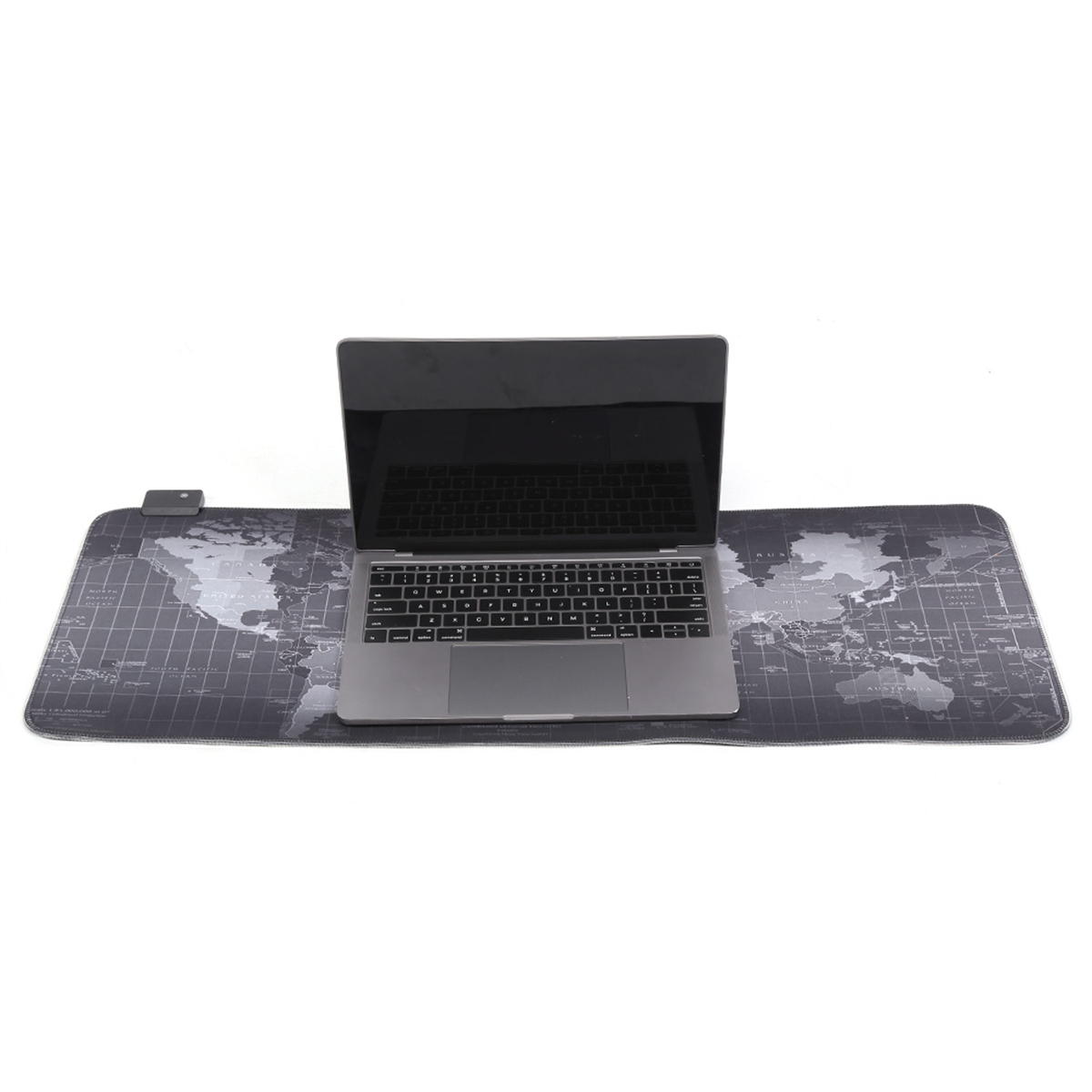 Laptop auf einer schwarzen Weltkarte-Mauspad. Tastatur sichtbar. Weißer Hintergrund.