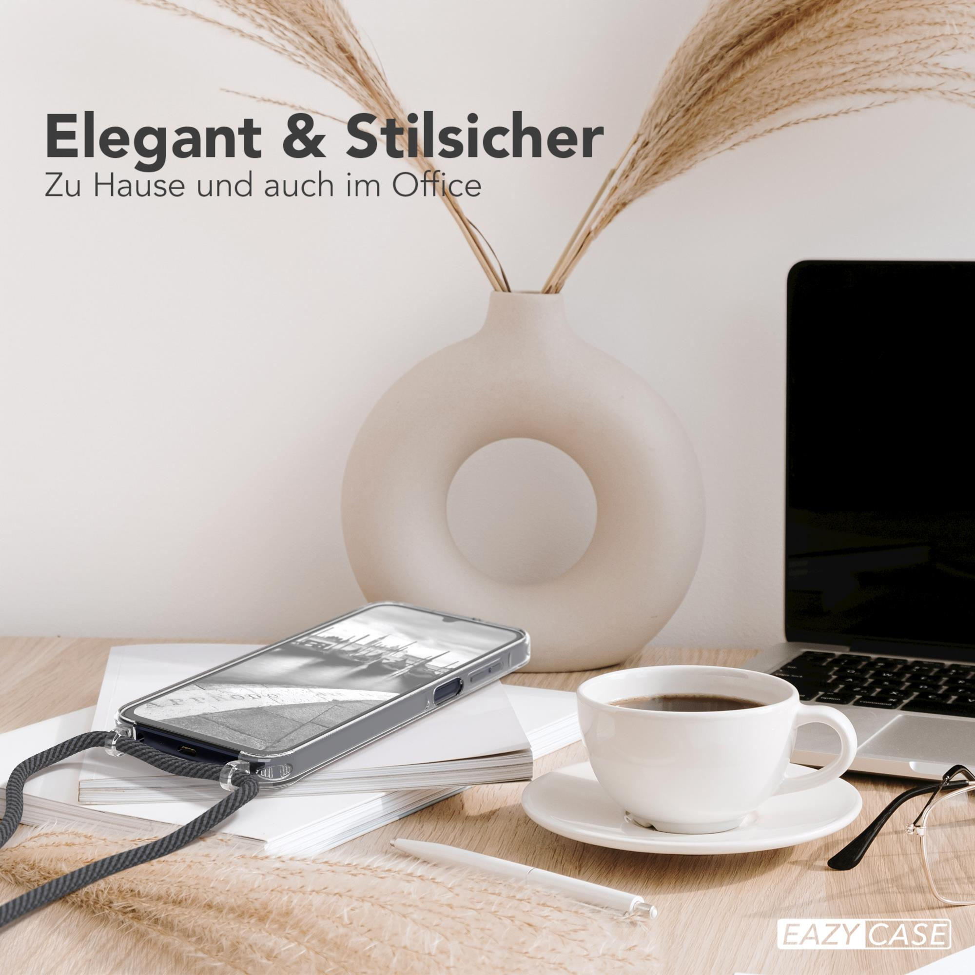 Telefon in Hülle mit Lanyard auf Schreibtisch mit Kaffee und Laptop im Hintergrund.