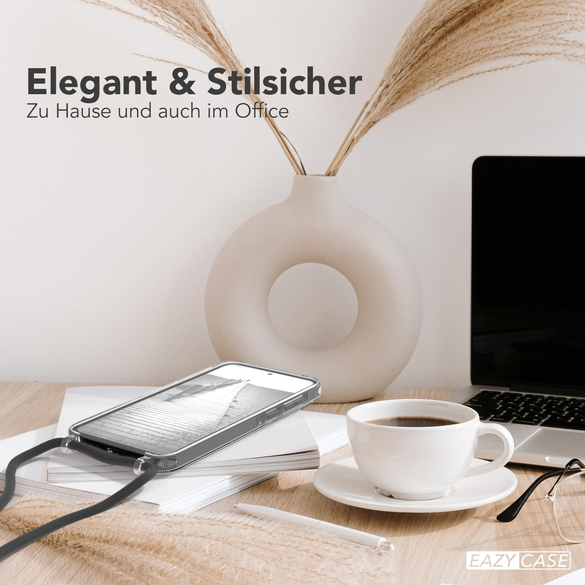 Ein Telefon mit Hülle, Kaffee und Vase auf einem Schreibtisch.