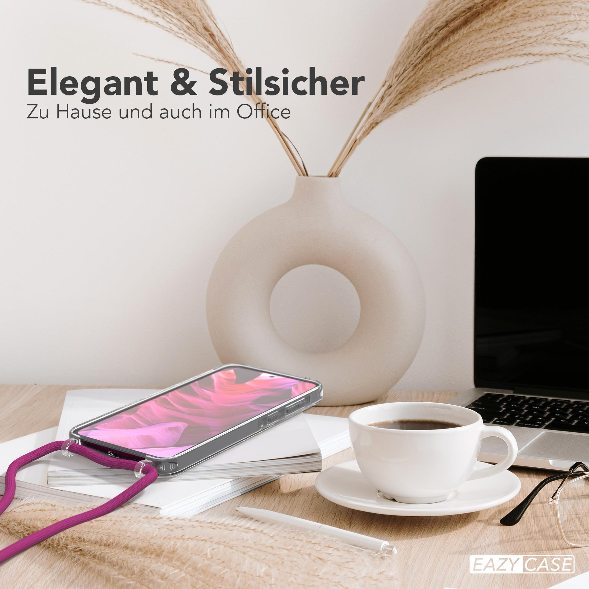 Eine Handyhülle mit fuchsiafarbenem Lanyard und Zubehör auf einem Schreibtisch, neben einer Kaffeetasse und Laptop.
