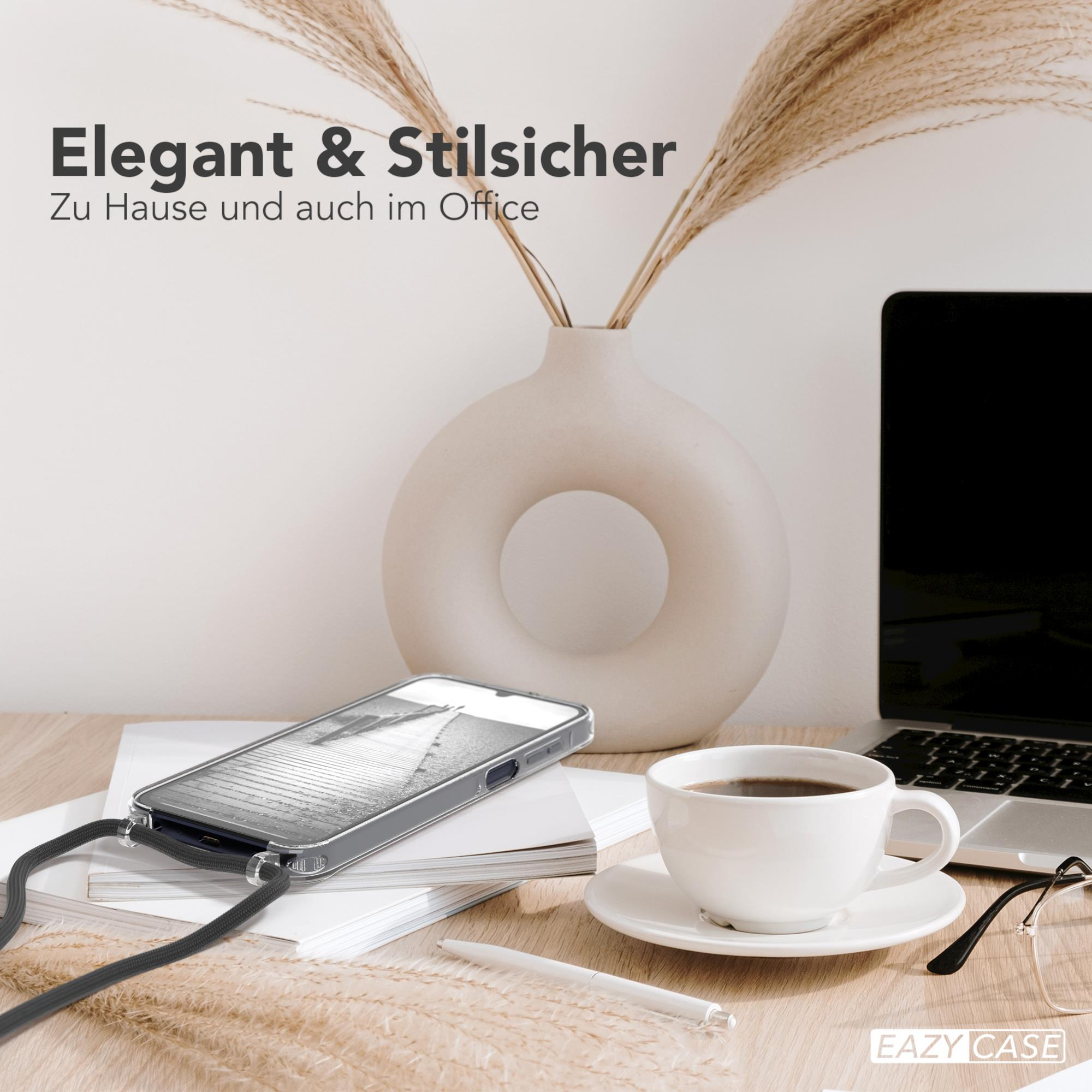 Ein Telefon mit Hülle und Lanyard auf einem Schreibtisch mit einer Kaffeetasse und einem Laptop.