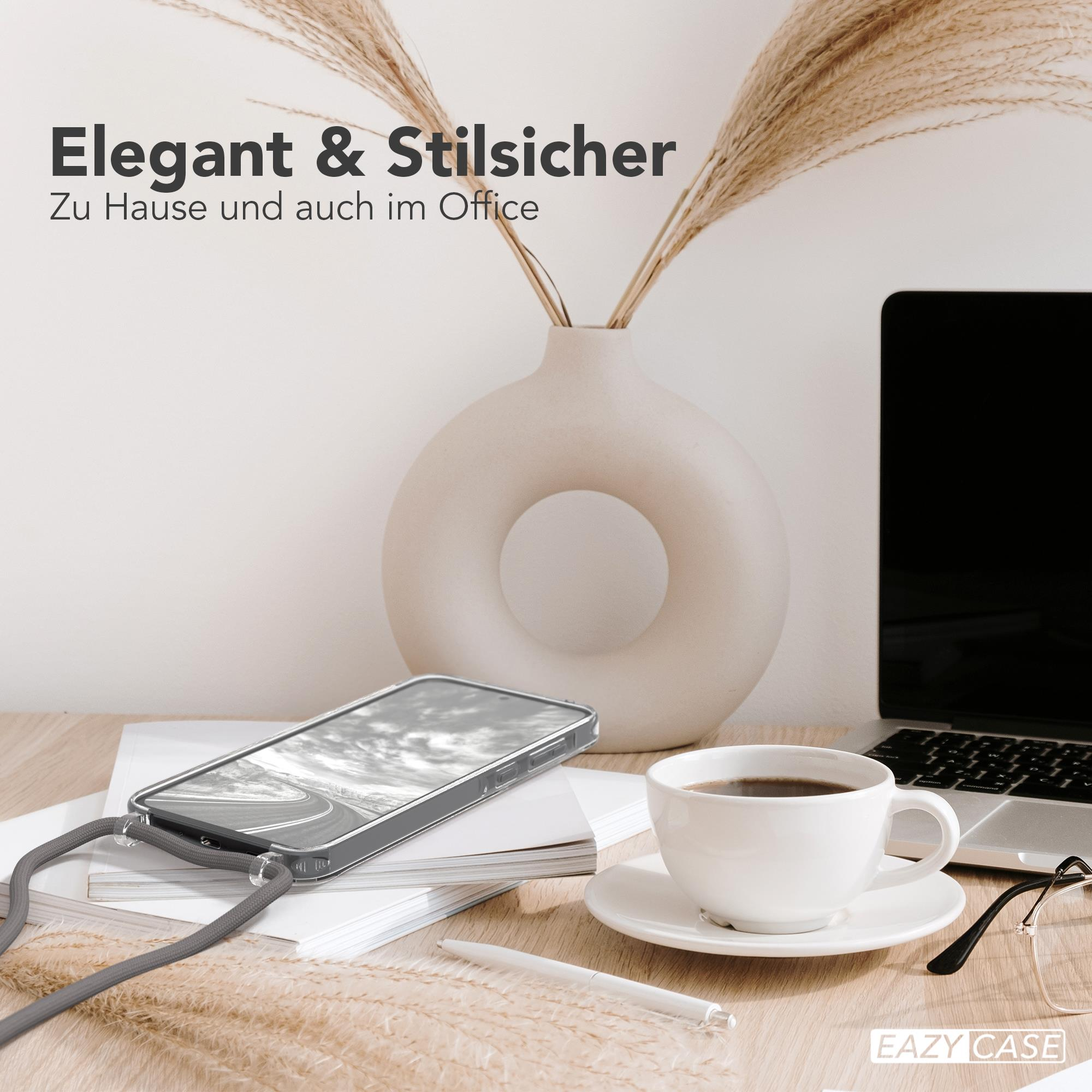 Telefon in klarer Hülle auf dem Schreibtisch. Eine weiße Tasse, Vase und Laptop sind auch vorhanden.